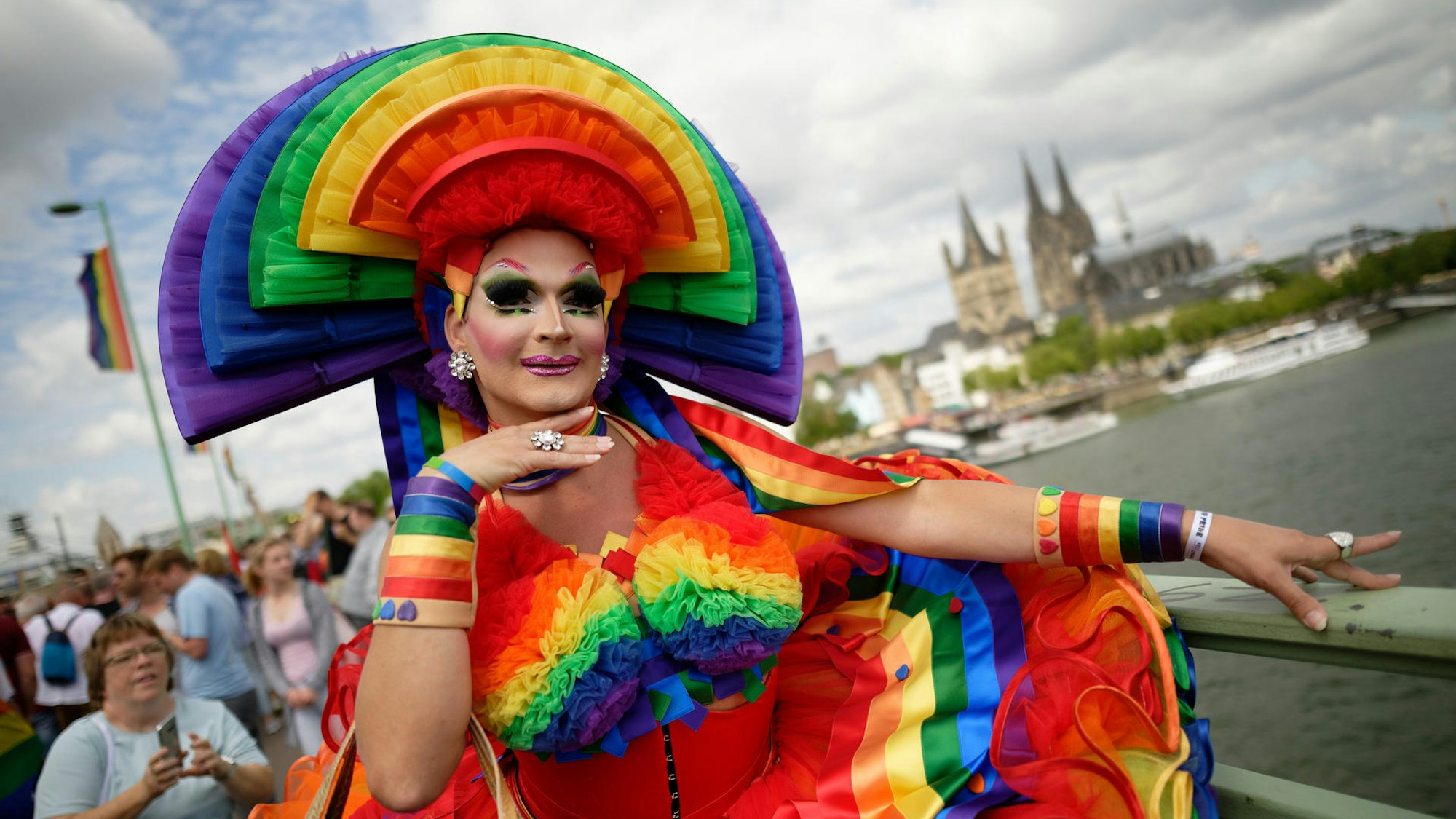Ein bunt gekleideter Mensch beim CSD im Kostüm.