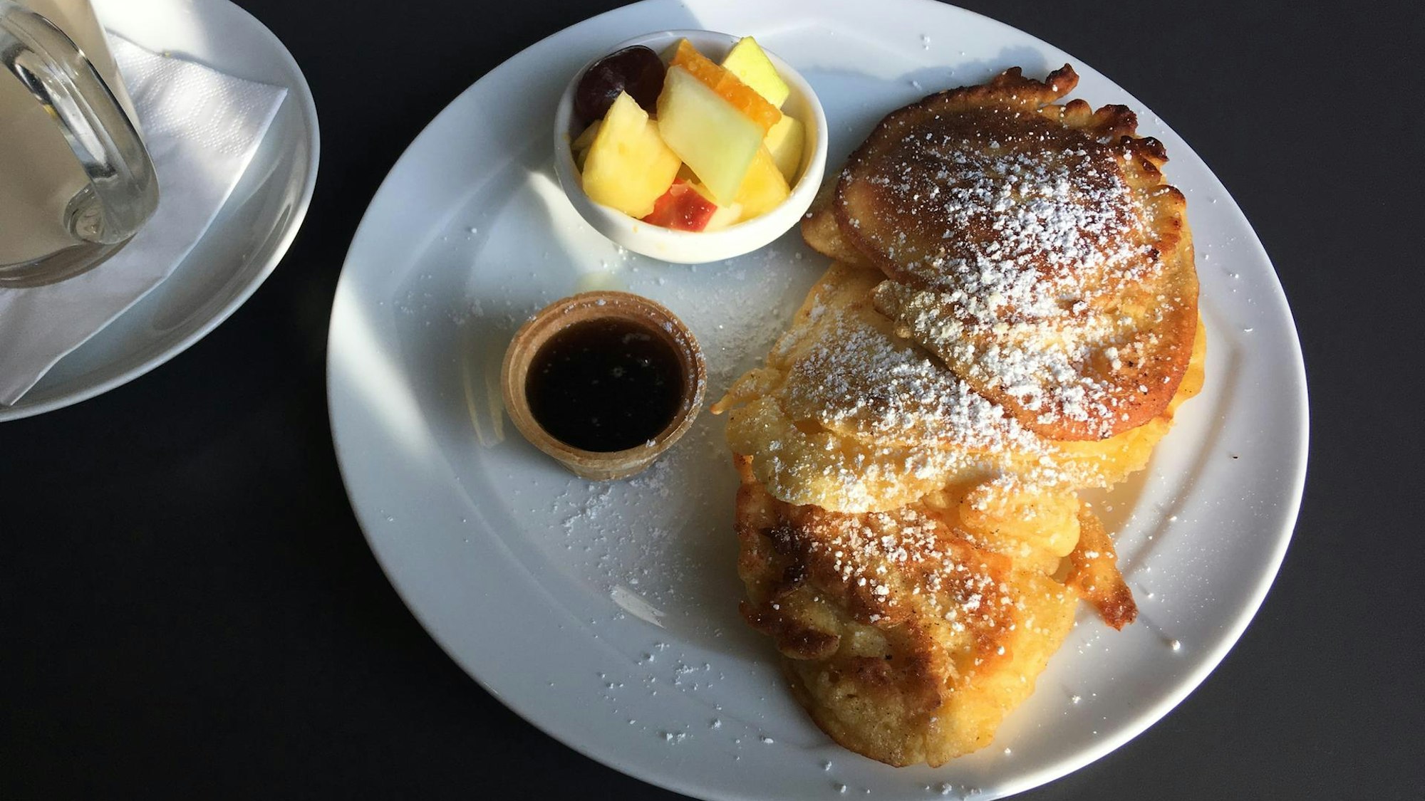Pancakes mit Puderzucker und einer kleinen Portion Obst im Café Jakubowski