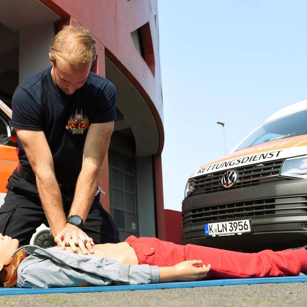 Ein Rettungssanitäter demonstriert an einer Puppe eine Herzdruckmassage.