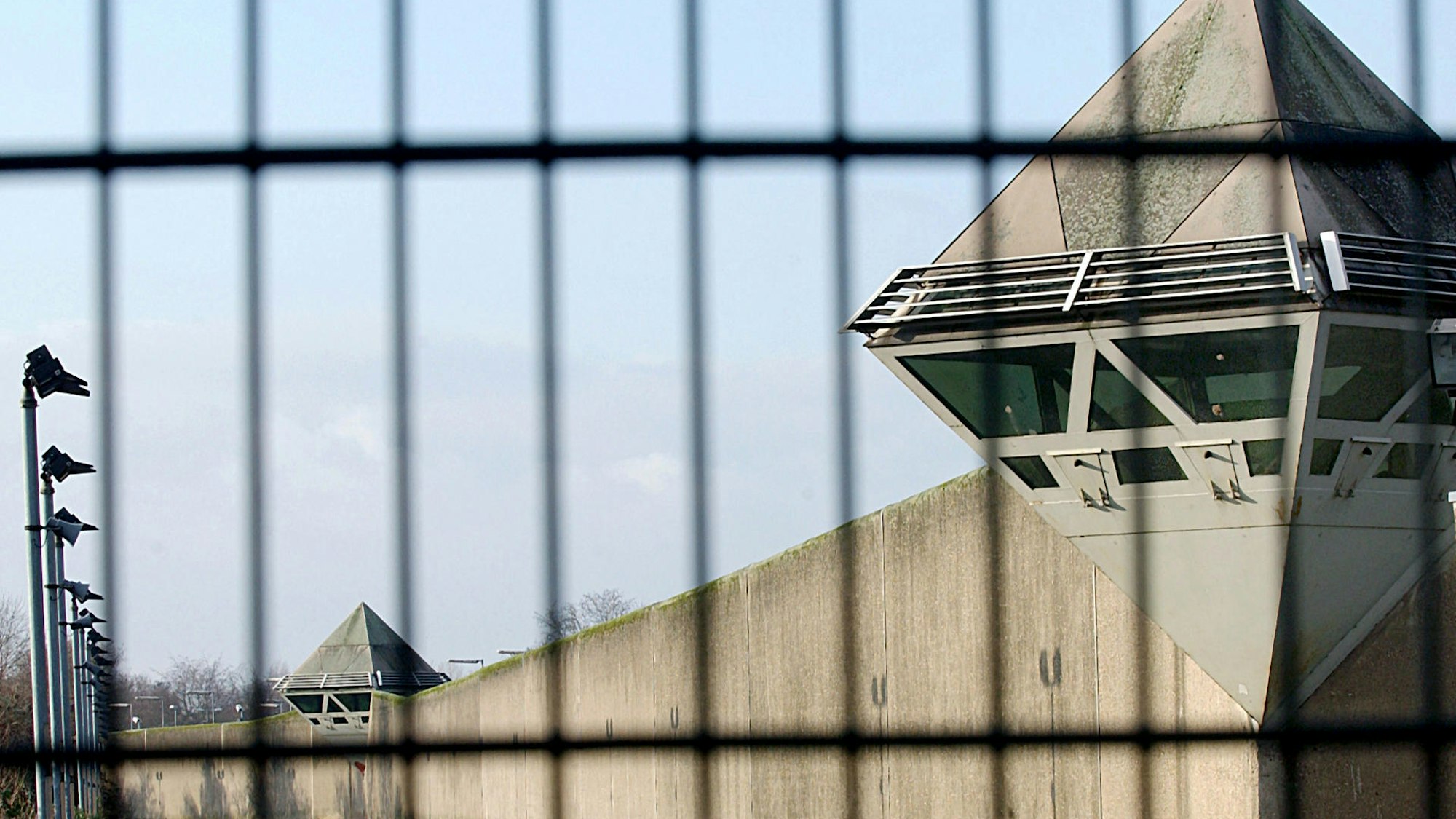Blick durch einen Zaun auf das Gebäude der JVA