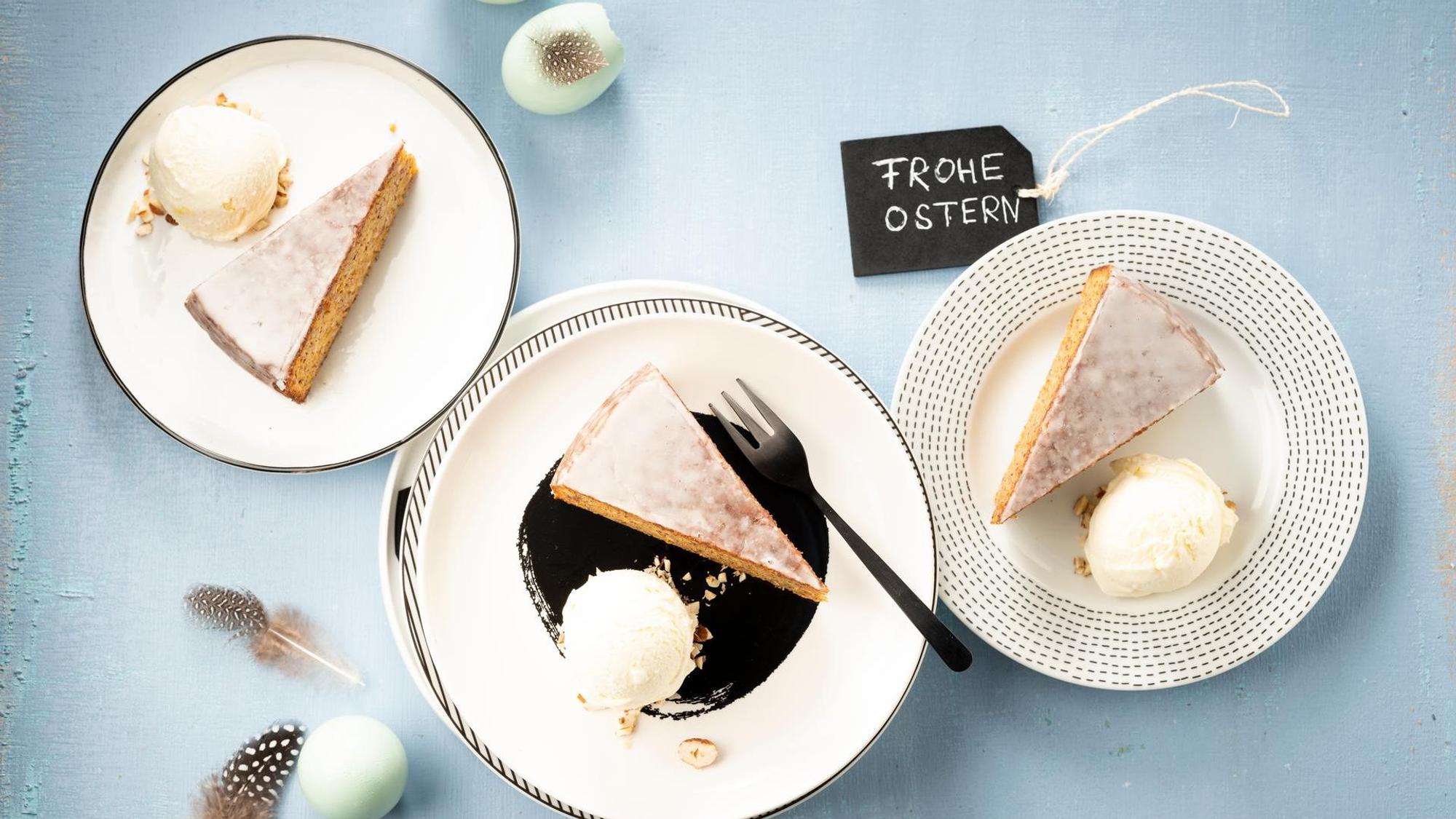 Tortenstücke neben einer Kugel Eis auf Tellern angerichtet