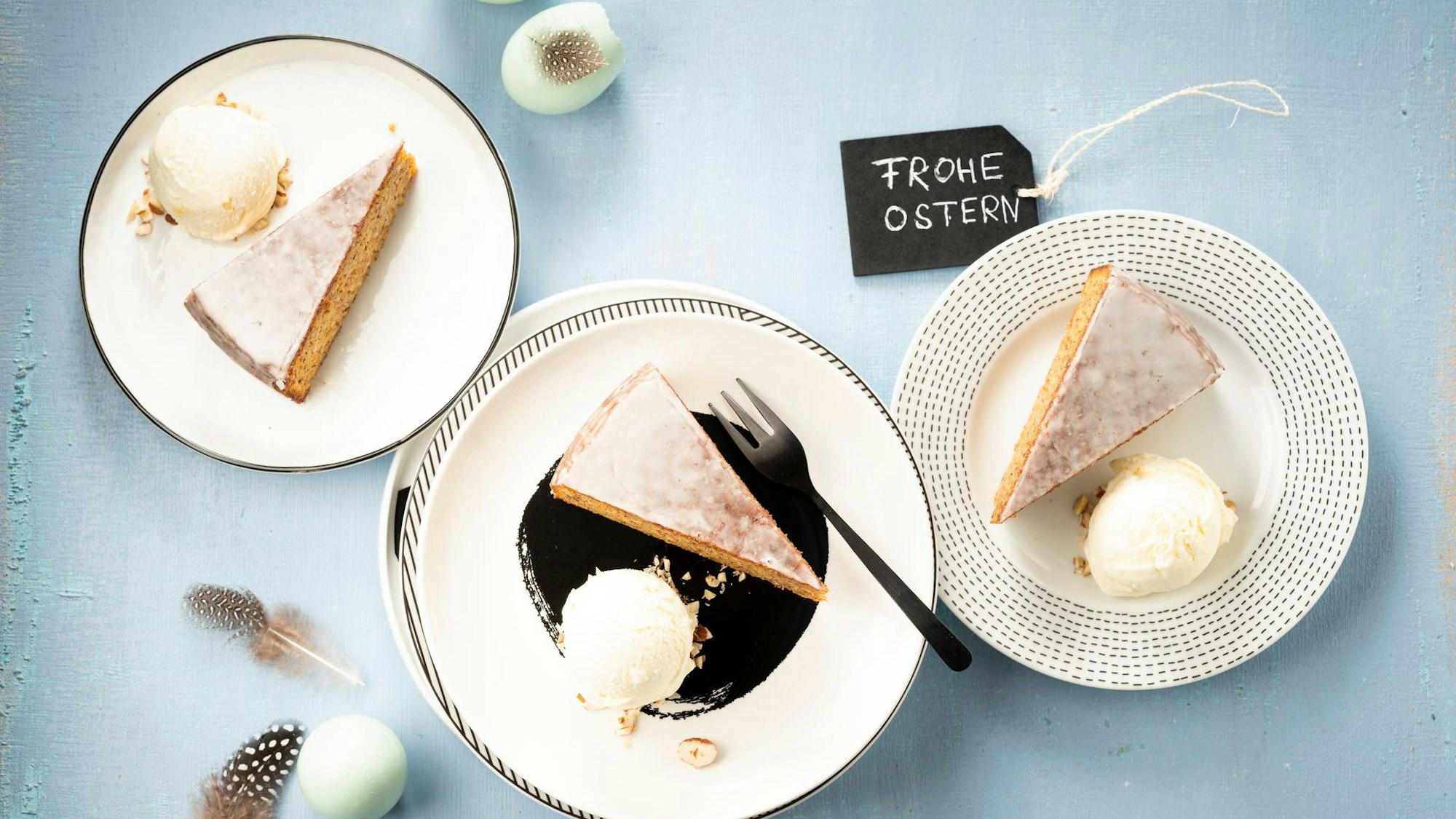 Tortenstücke neben einer Kugel Eis auf Tellern angerichtet