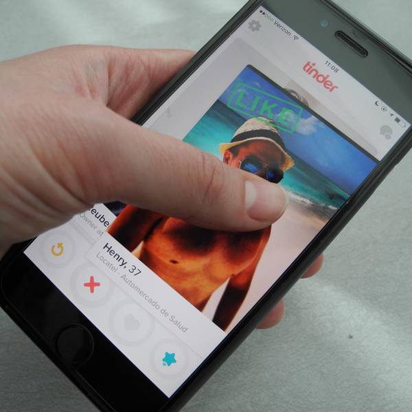 Eine_Frau_hält_ihr_Smartphone_in_der_Hand_auf_dem_Bildschirm_ist_die_App_Tinder