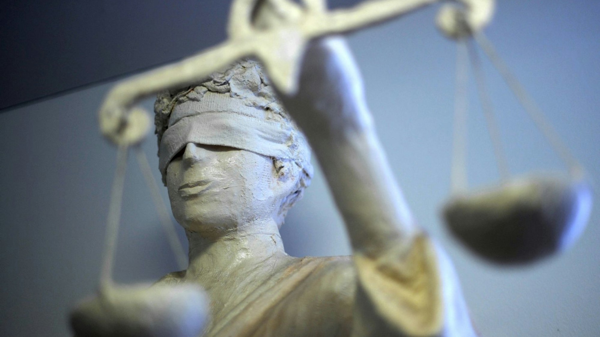 Eine Justitia-Statue hält mit verbundenen Augen eine Wage in der Hand.