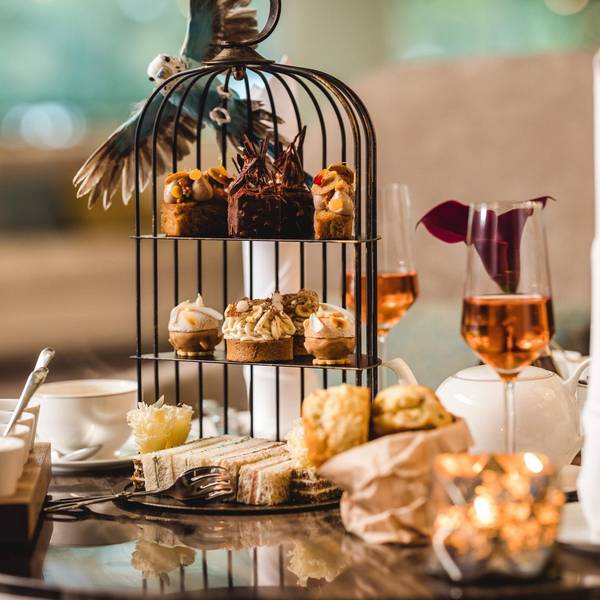 Eine reich gedeckte Tea Time Tafel mit einer Etagere und vielen Snacks