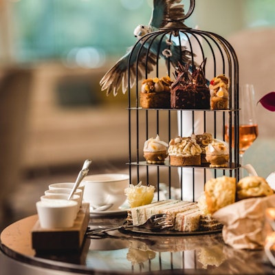 Eine reich gedeckte Tea Time Tafel mit einer Etagere und vielen Snacks