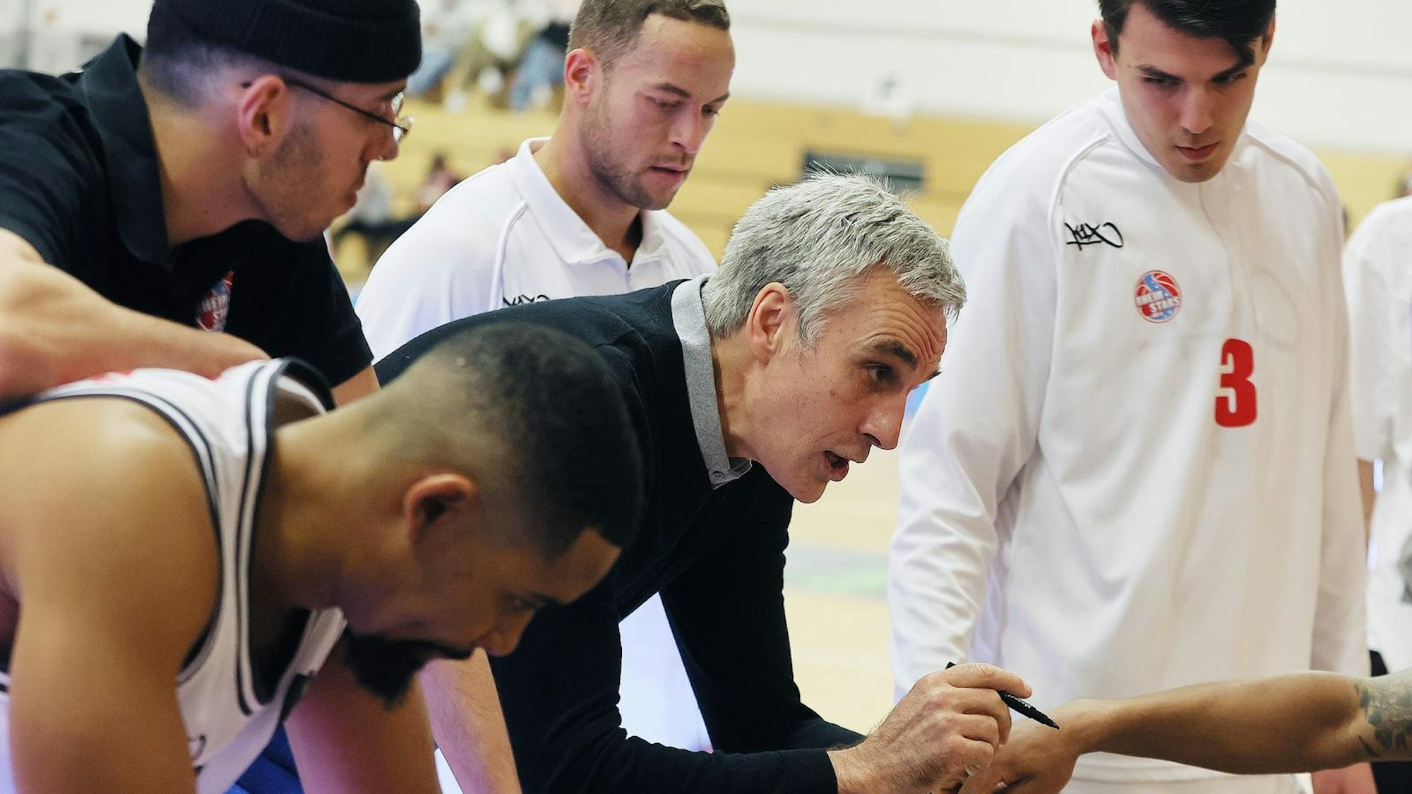 Ein Basketballtrainer spricht während einer Auszeit mit seinem Team.