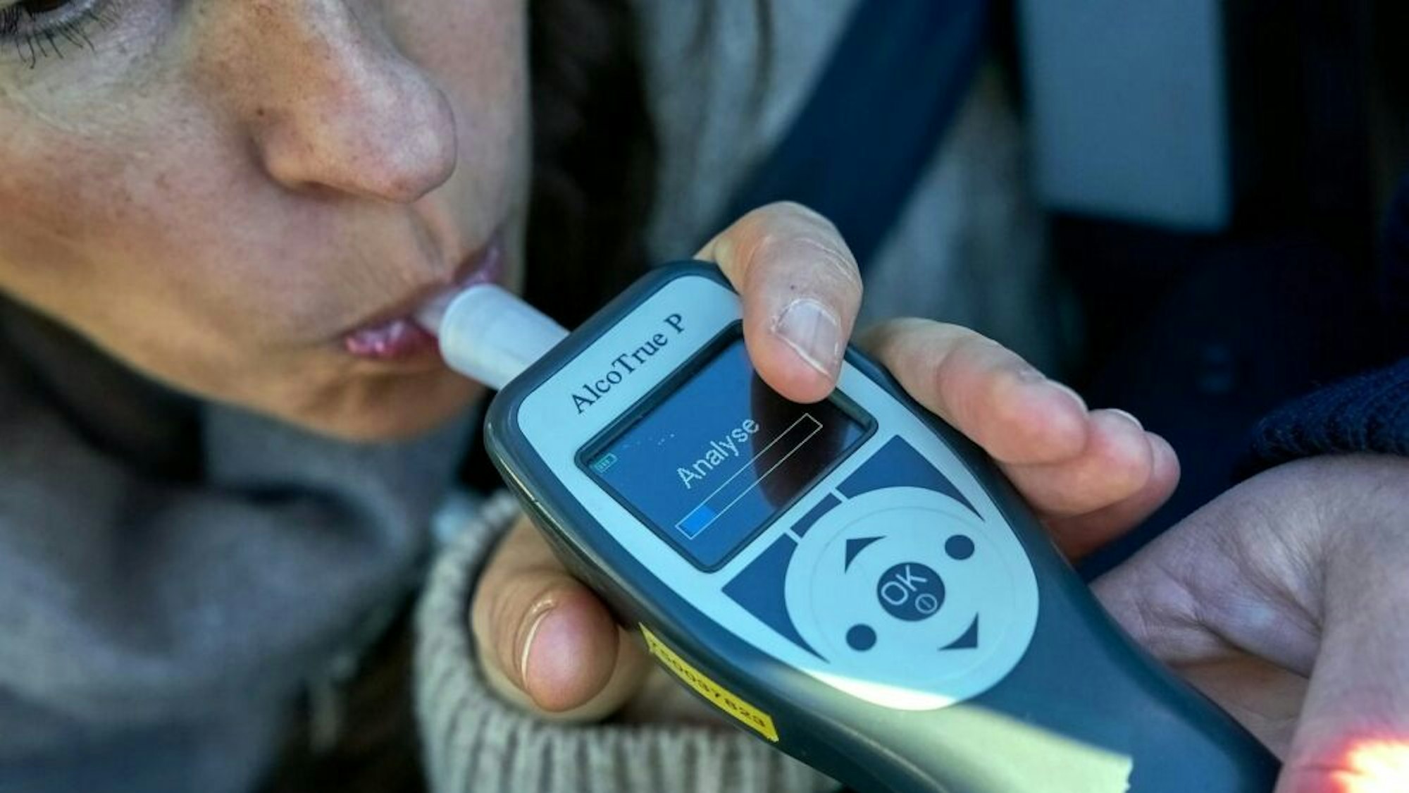 Eine Frau führt einen Atemalkoholtest durch.