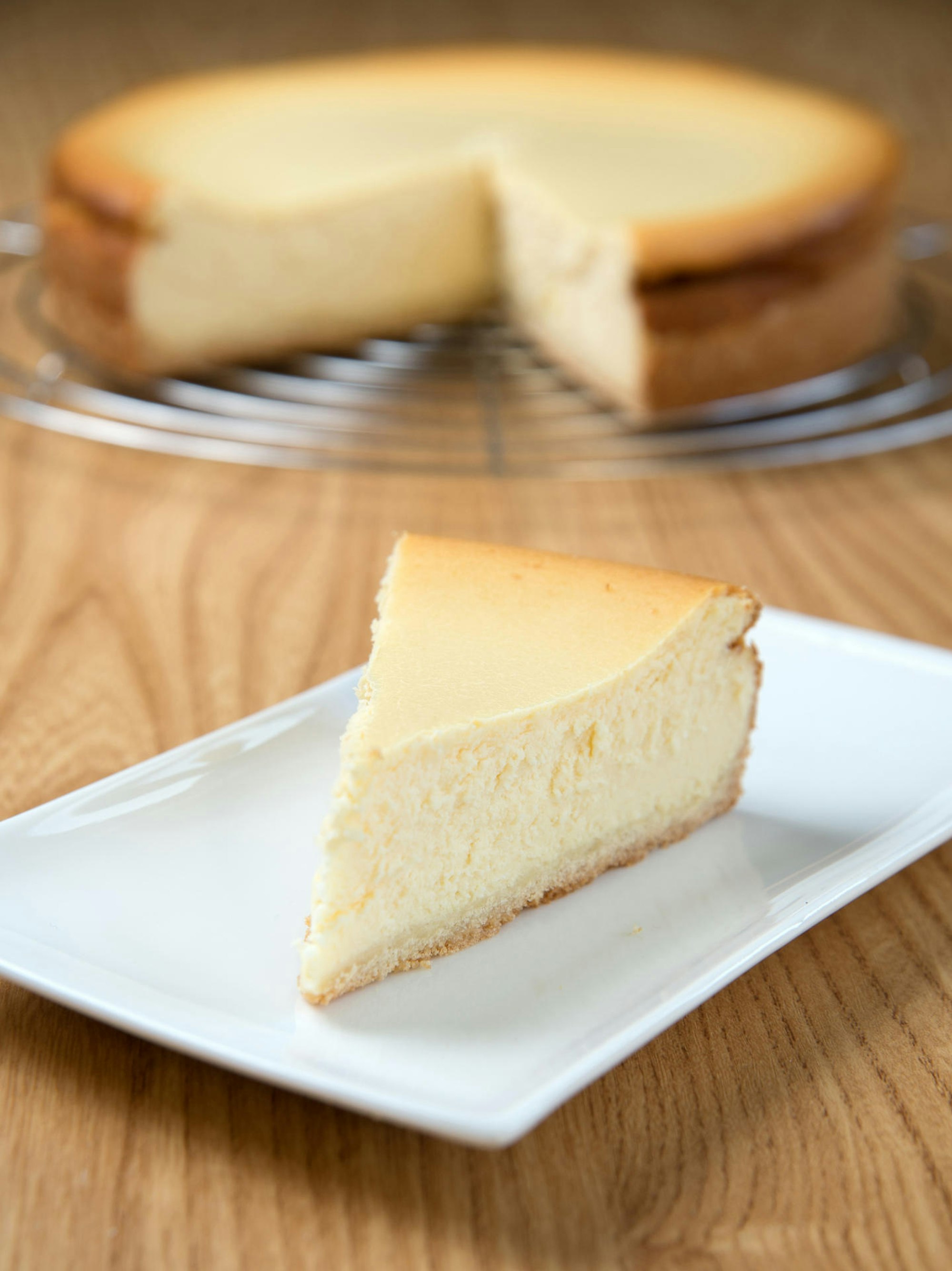 käsekuchen stück und kuchen im hintergrund