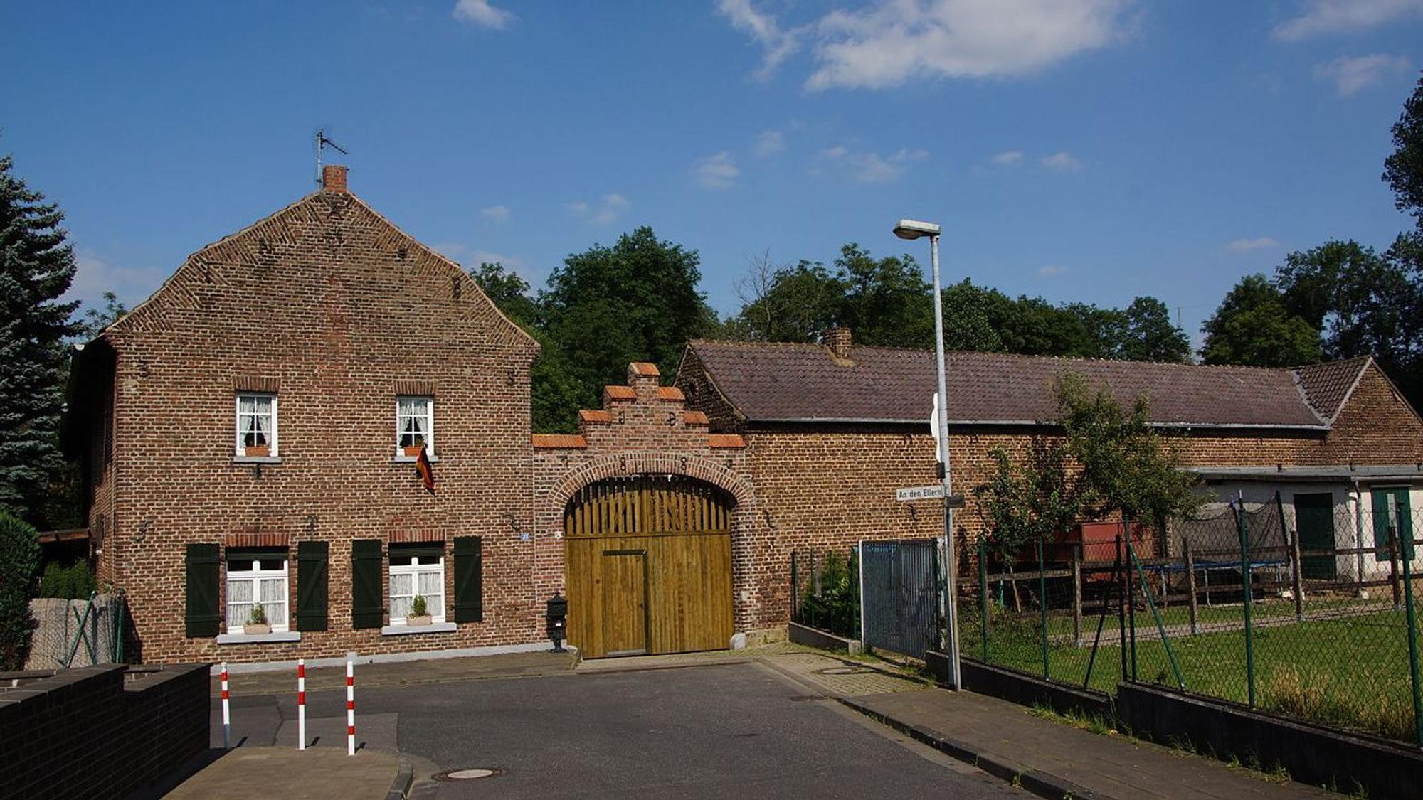 Gebäude aus Backstein mit einem Holztor.