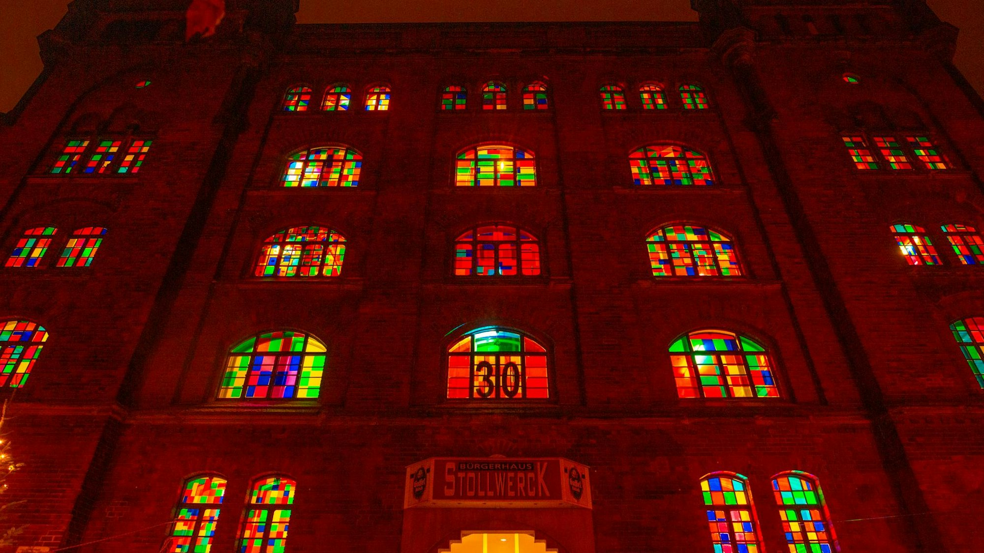 Bunte Fenster eines alten Gebäudes leuchten im Dunkeln