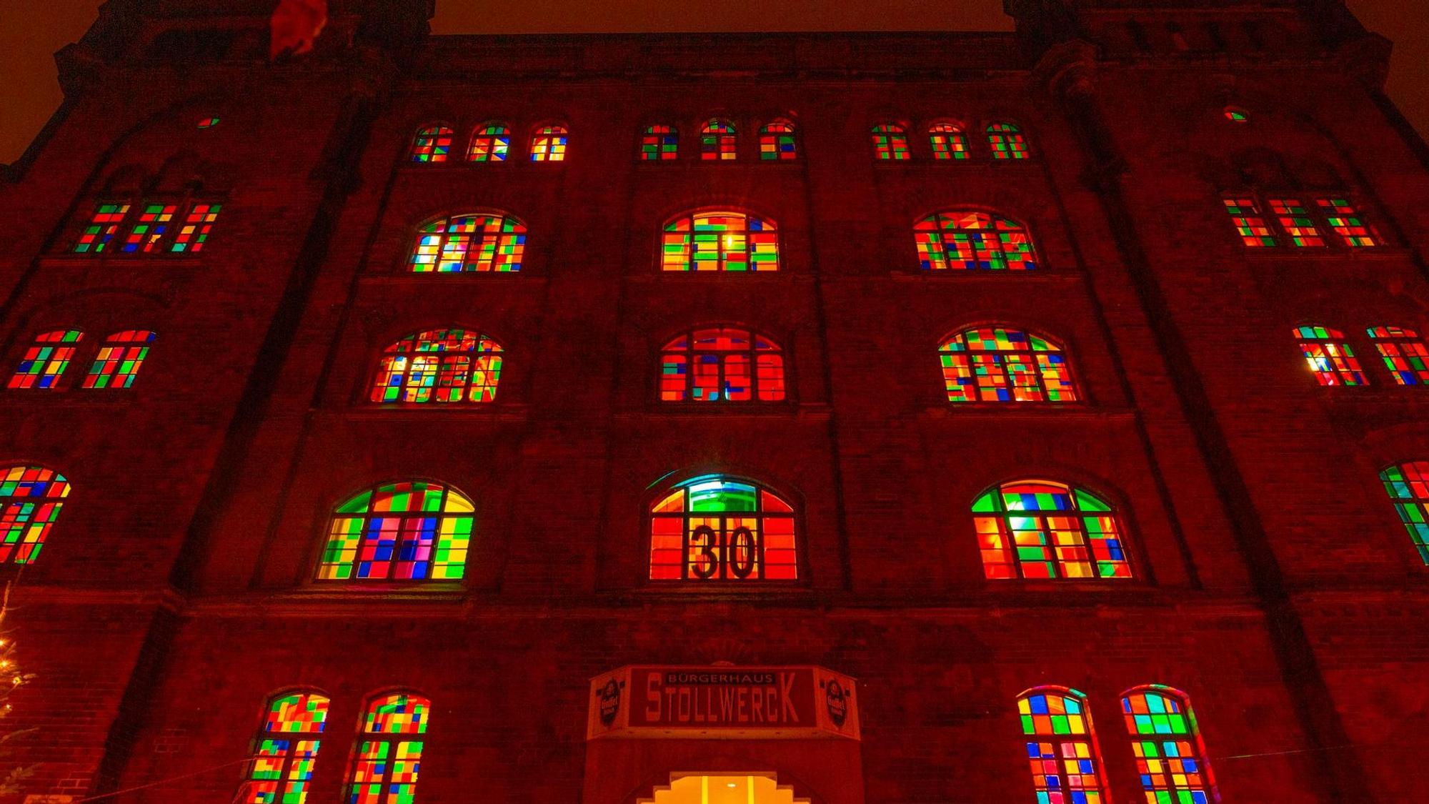 Bunte Fenster eines alten Gebäudes leuchten im Dunkeln