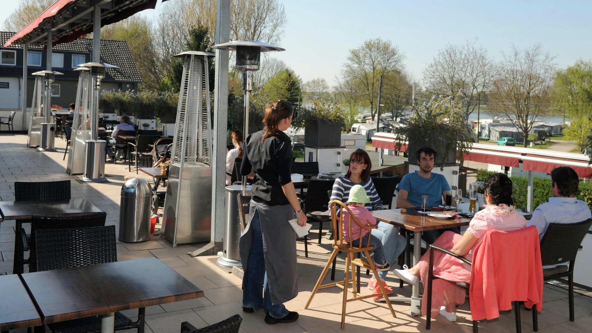 Menschen sitzen auf einer Terrasse.