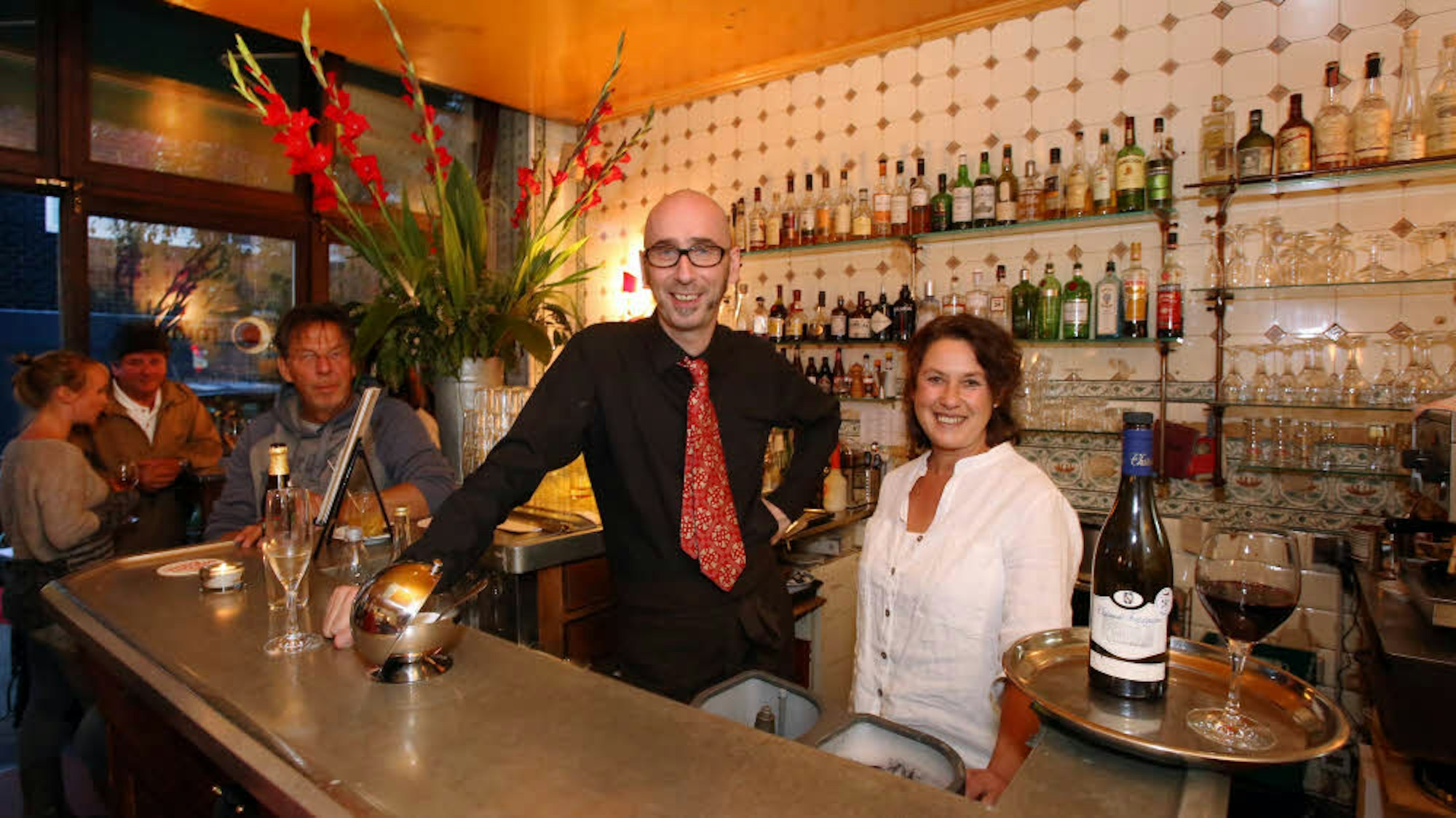 ein Mann und eine Frau stehen hinter einem Bartresen