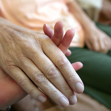 Ein_junger_Mensch_hält_eine_älteren_an_der_Hand_Palliativmedizin_Symbolbild_