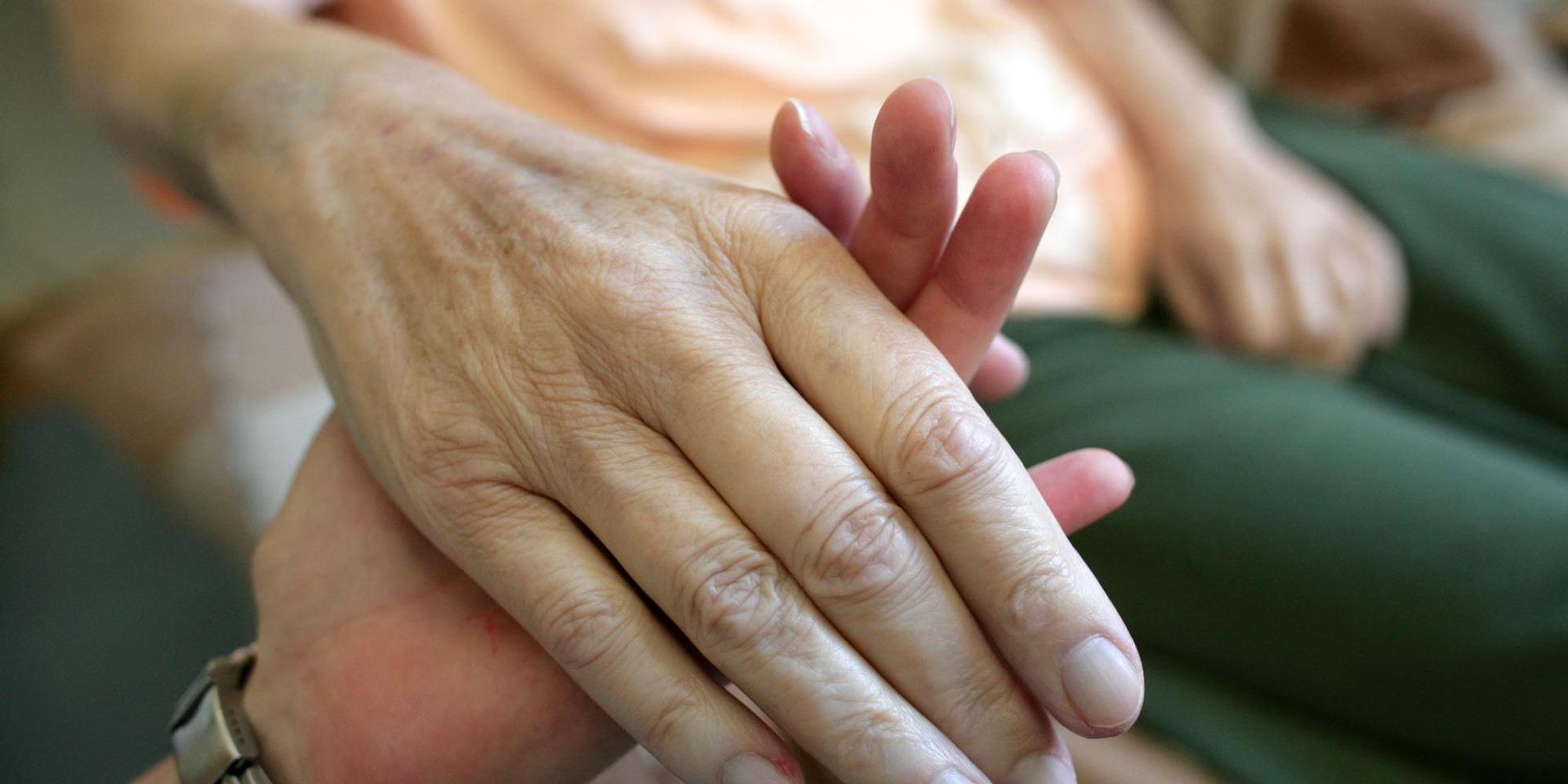 Ein_junger_Mensch_hält_eine_älteren_an_der_Hand_Palliativmedizin_Symbolbild_