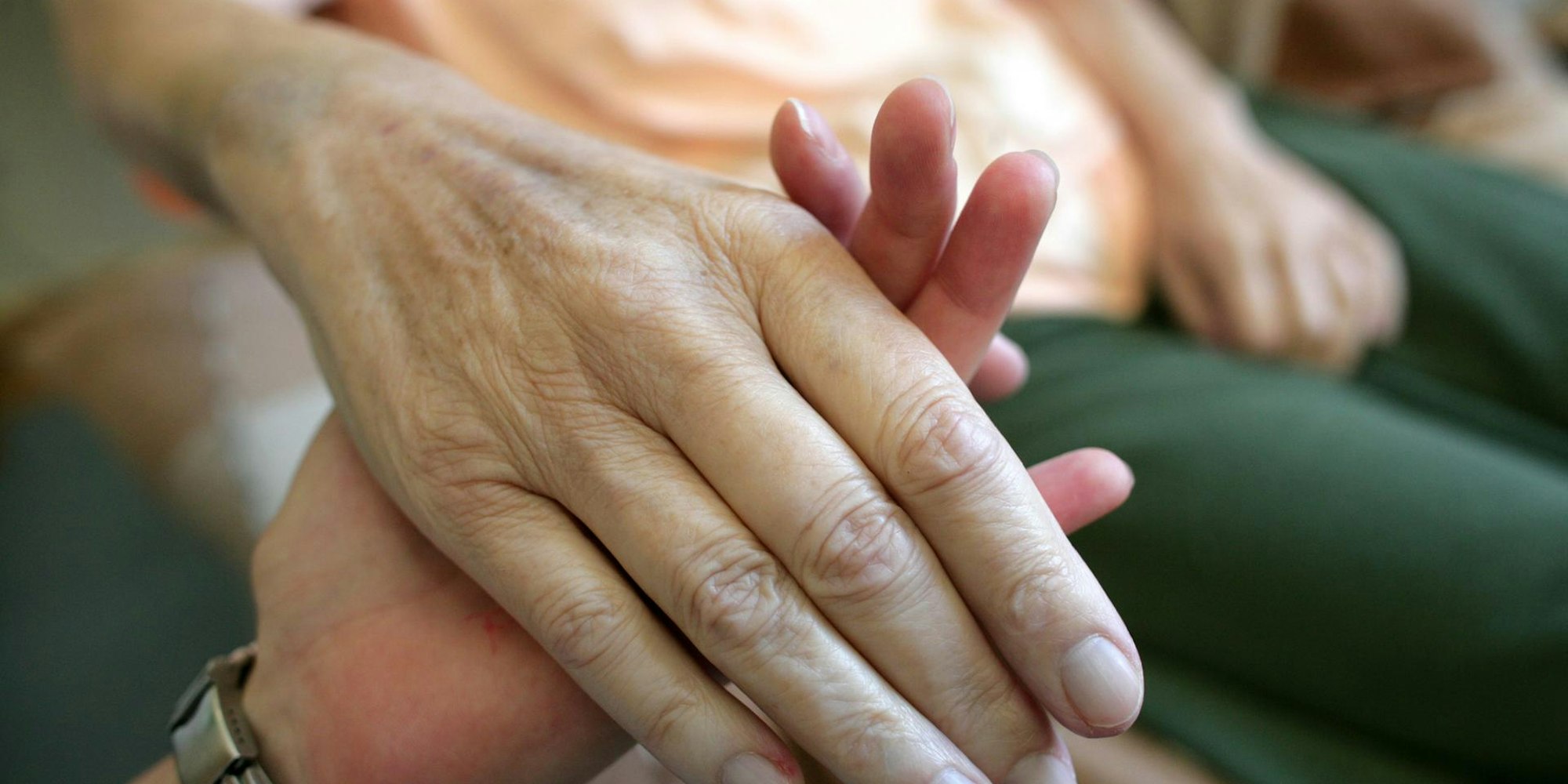 Ein_junger_Mensch_hält_eine_älteren_an_der_Hand_Palliativmedizin_Symbolbild_