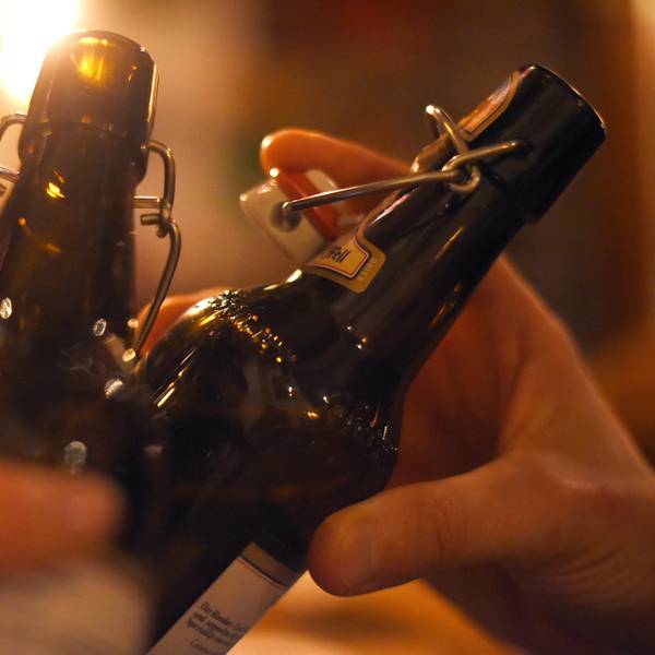 Das Symbolfoto zeigt zwei Bierflaschen mit Bügelverschluss, mit denen angestoßen wird.
