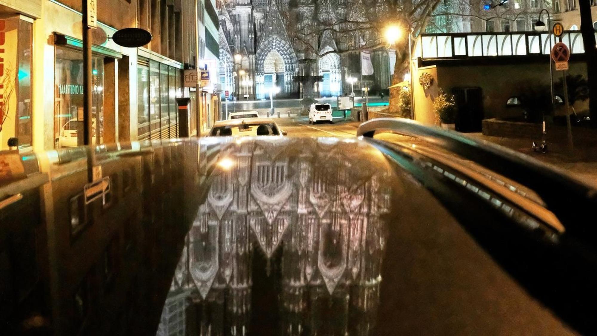Der Dom spiegelt sichauf einem schwarzen Autodach.