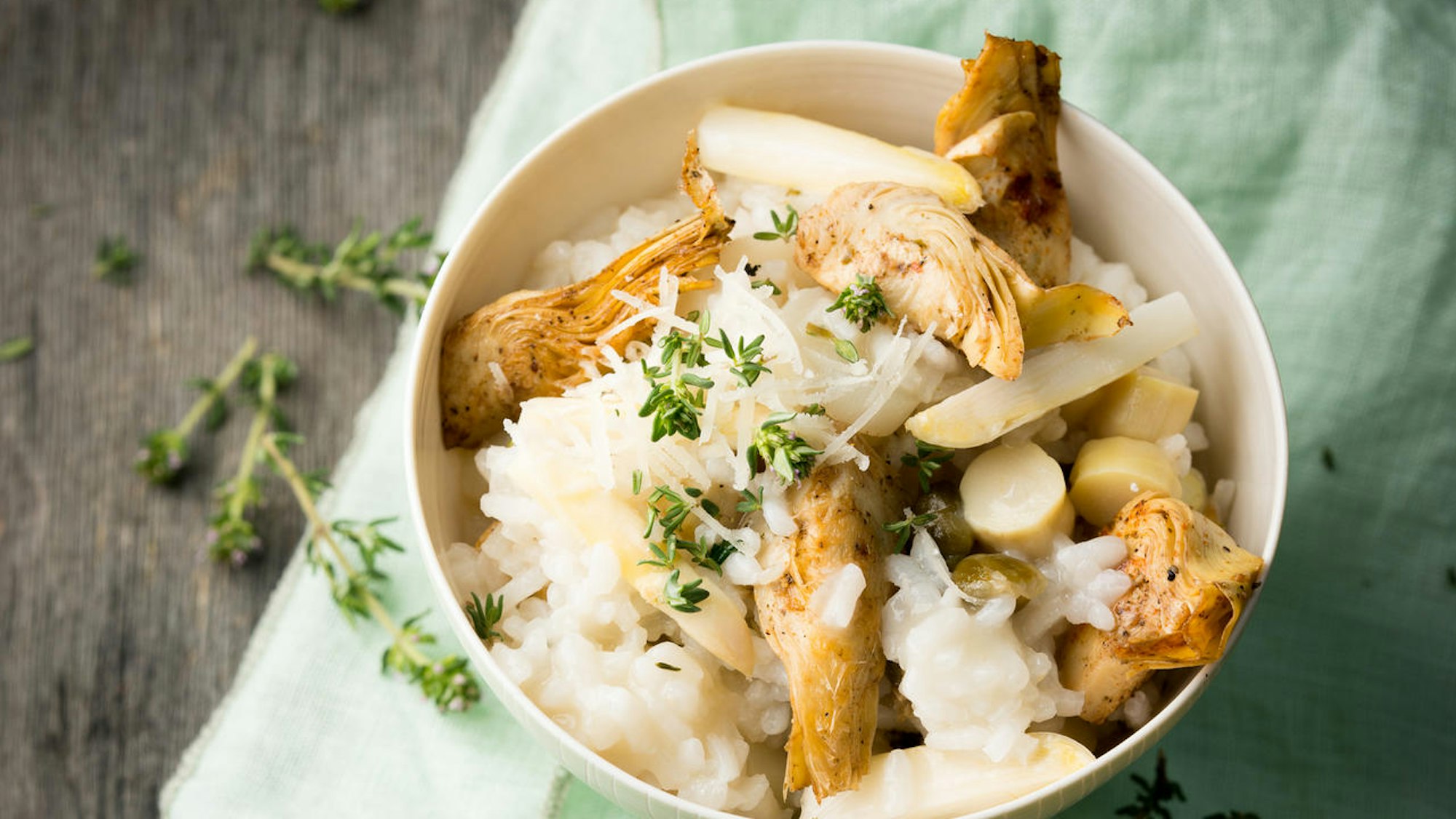 Spargelrisotto mit Artischocken und Kapern, angerichtet in einer Schüssel