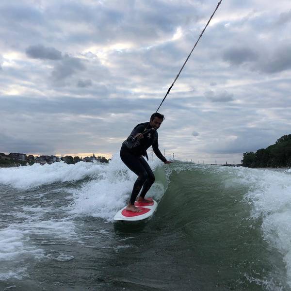 Ein junger Mann surft auf dem Rhein.