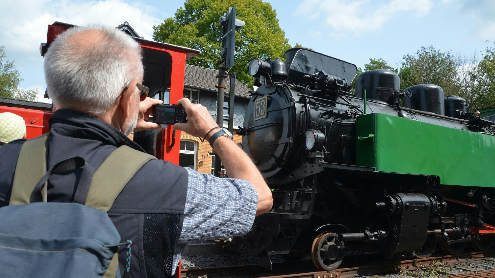 Ein Mann fotografiert eine alte Eisenbahn.