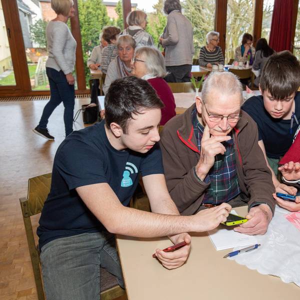 Schüler und Senioren am Handy