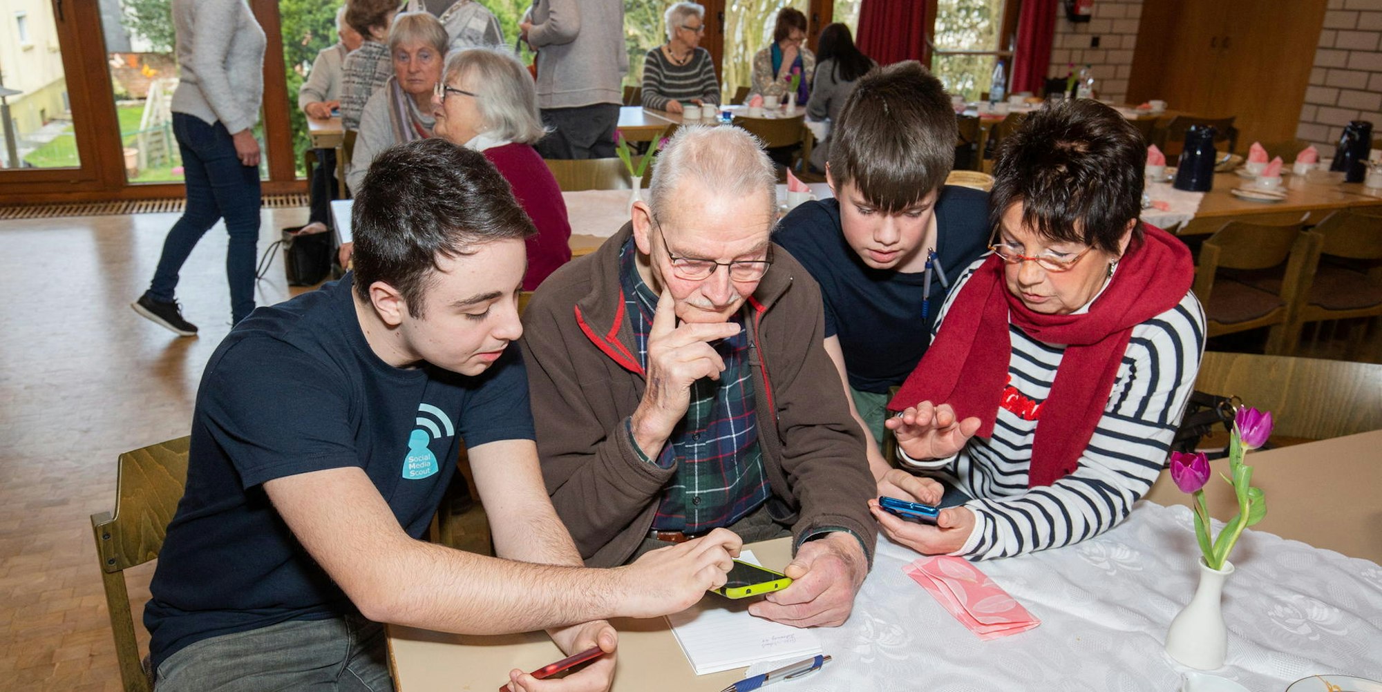 Schüler und Senioren am Handy