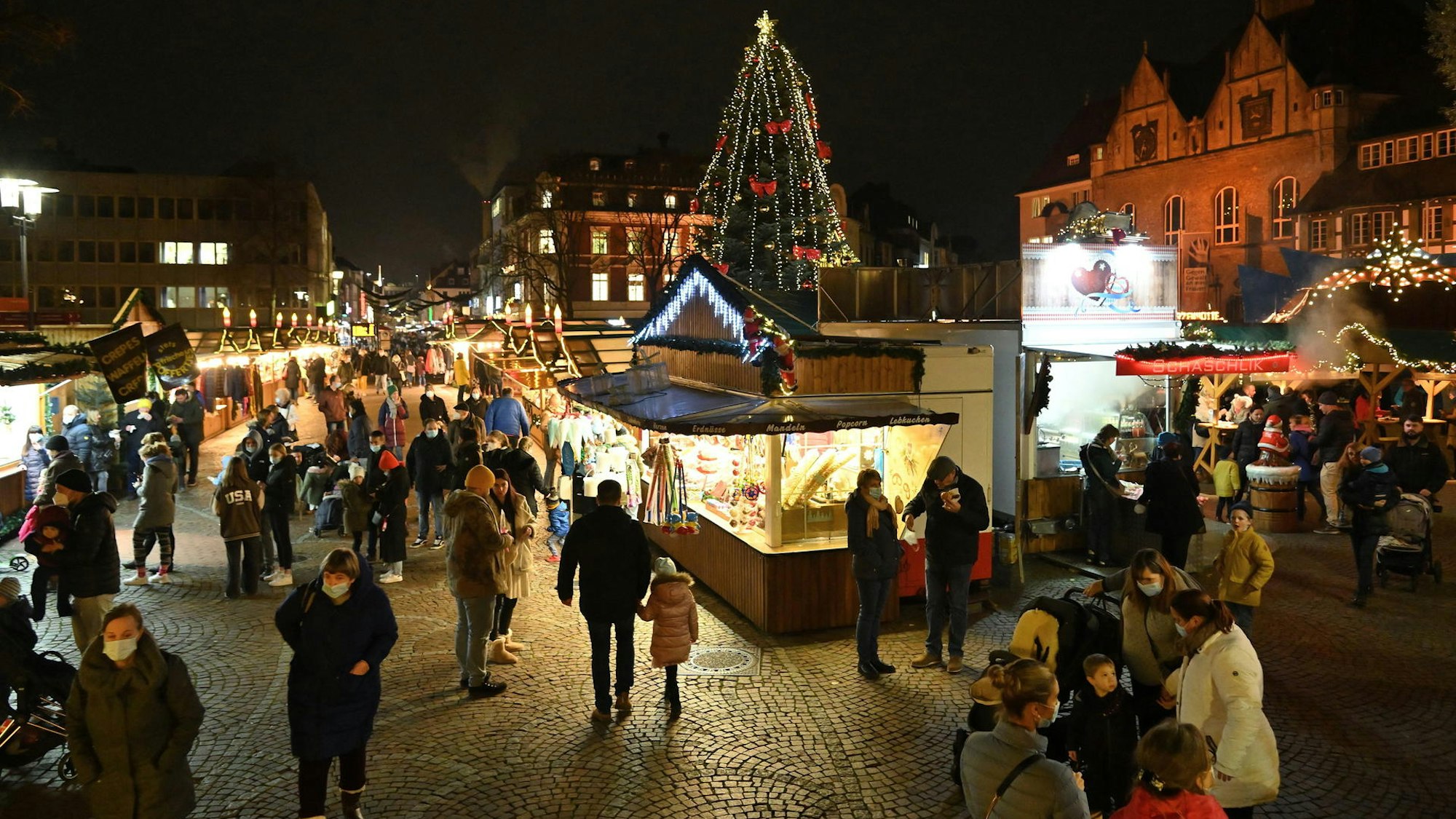 Viele Menschen gehen auf dem Weihnachtsmarkt an den Buden vorbei.