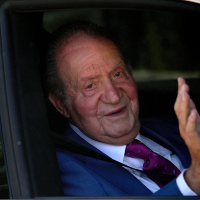 Juan Carlos winkt in einem Auto.