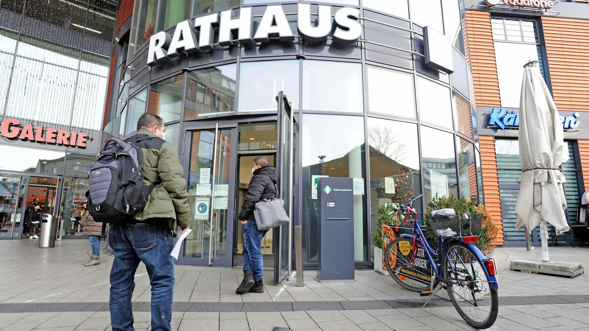 Menschen warten vor dem Eingang zum Rathaus