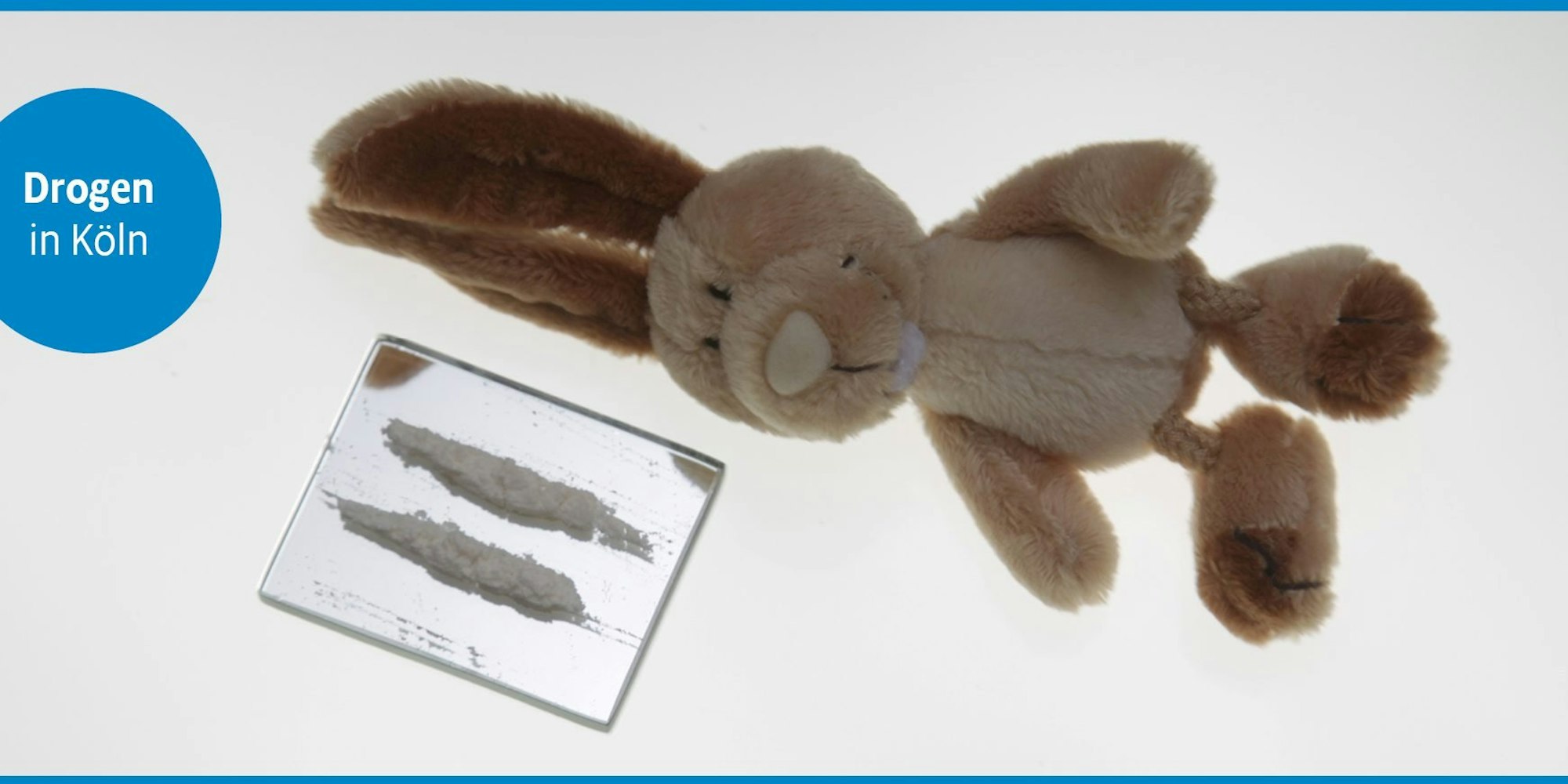 Ein Plüschhase liegt neben einer Linie Koks.