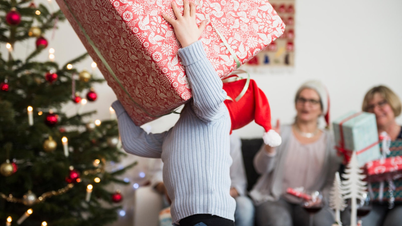 Kind trägt ein riesiges Geschenk