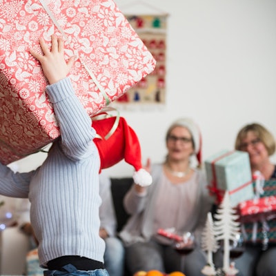 Kind trägt ein riesiges Geschenk