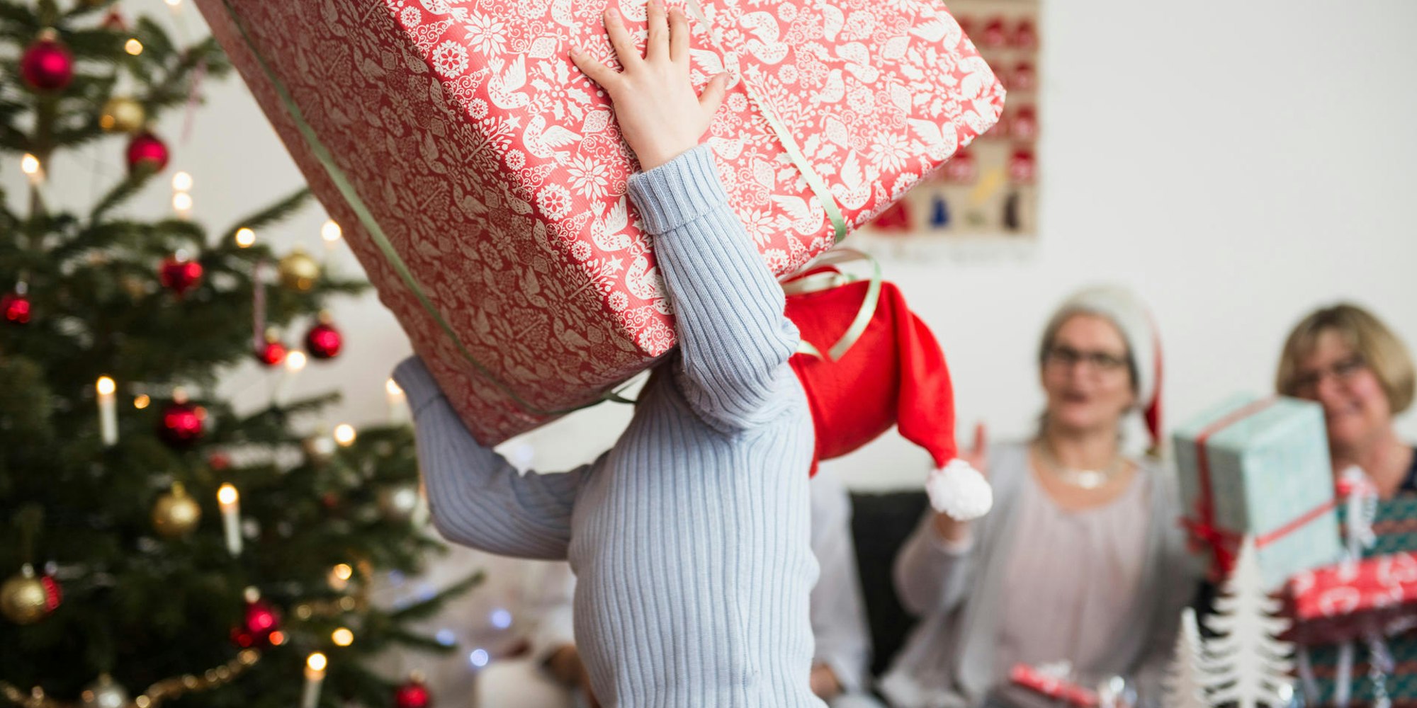 Kind trägt ein riesiges Geschenk