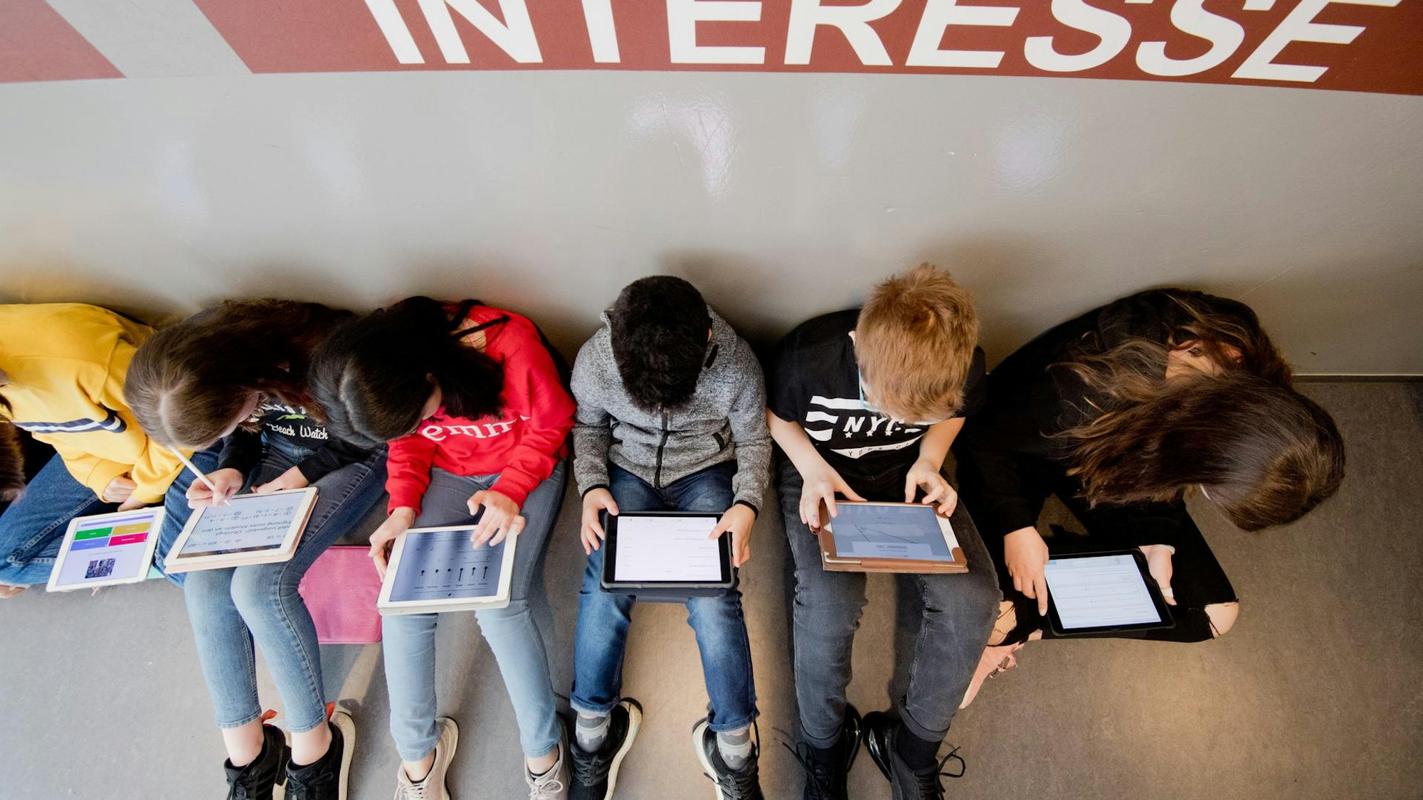 Auf dem Bild sind Kinder zu sehen, die Tablets benutzen