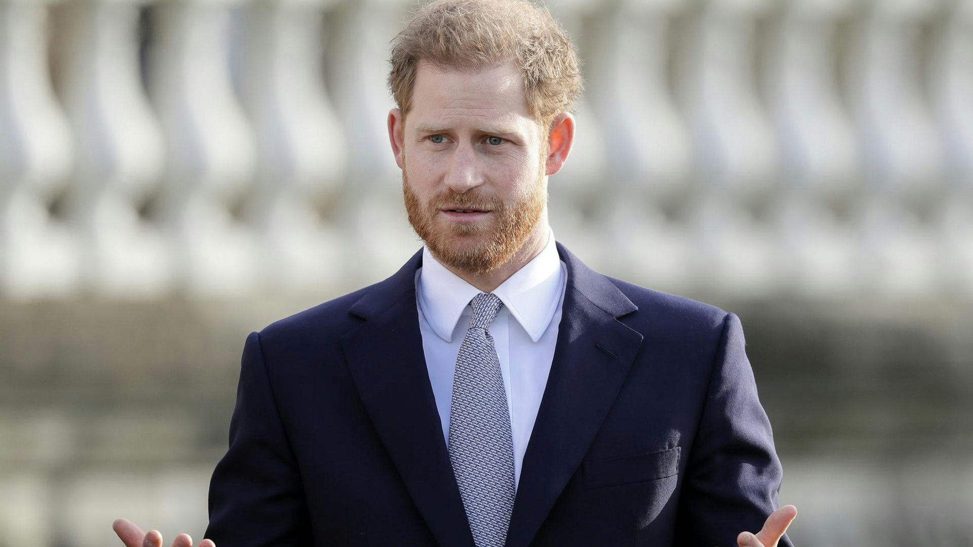 Prinz Harry, der Herzog von Sussex, hebt fragend beide Hände.