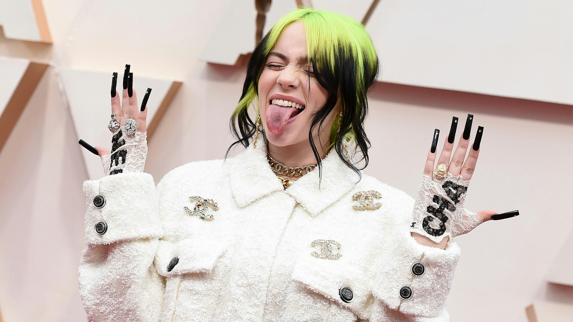 Billie Eilish streckt die Zunge raus und posiert.