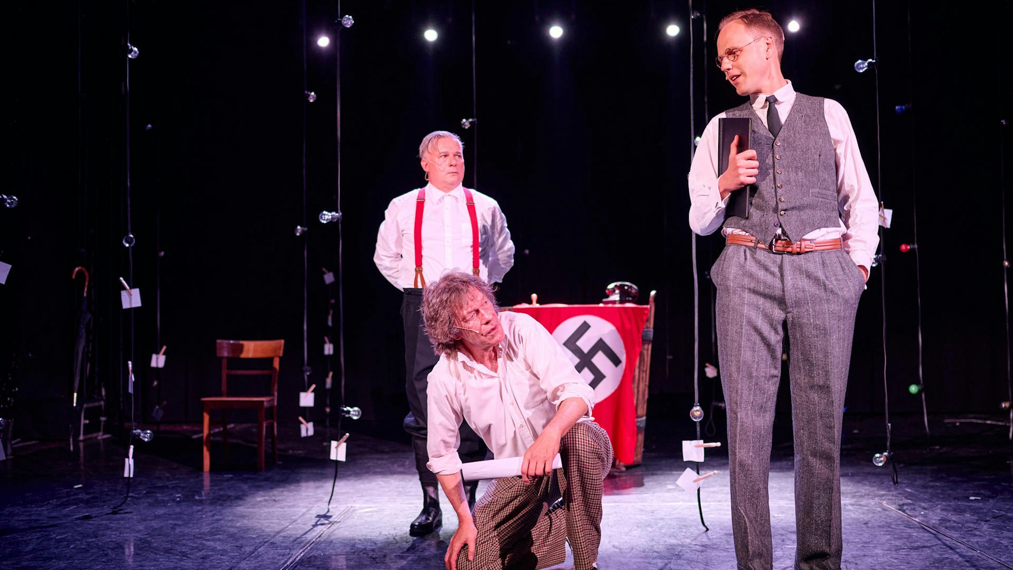 Drei Männer auf einer Bühne.