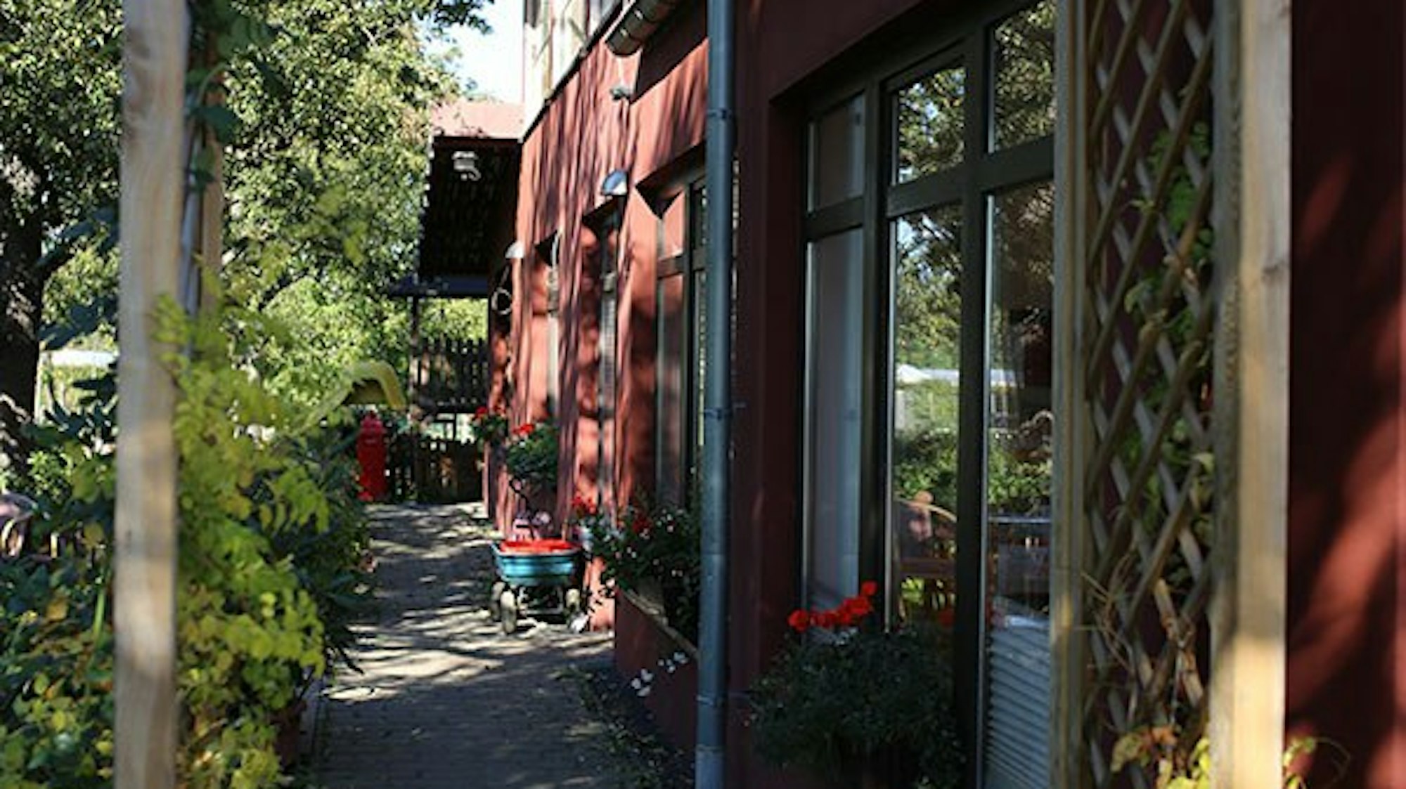 Blick auf einen Gehweg entlang eines roten Hauses