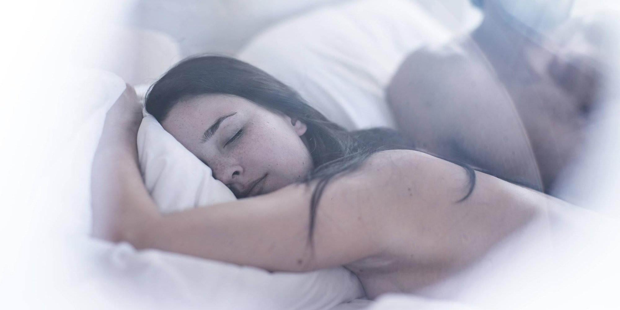 Frau_schläft_Mann_unscharf_im_Hintergrund