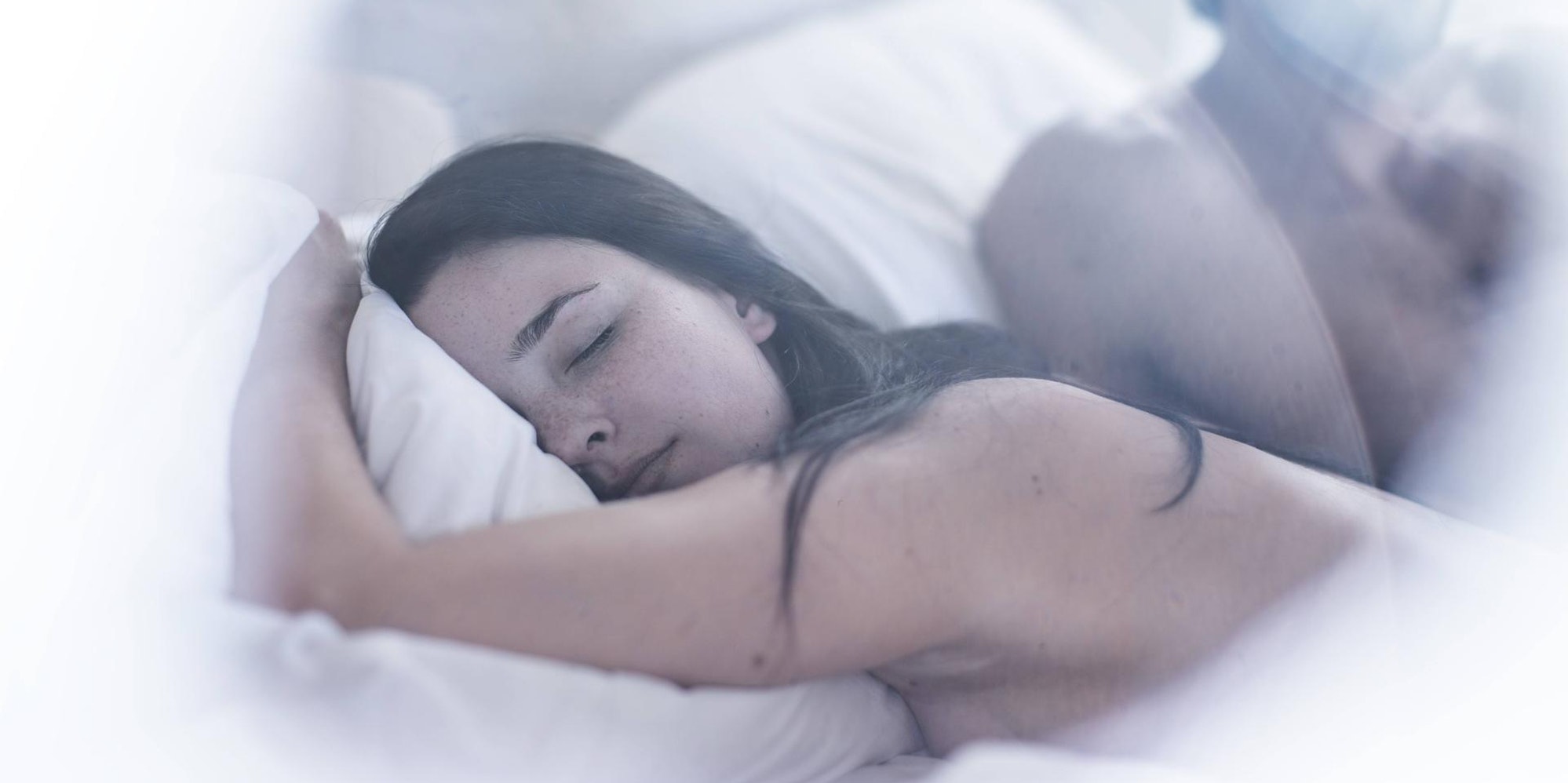 Frau_schläft_Mann_unscharf_im_Hintergrund