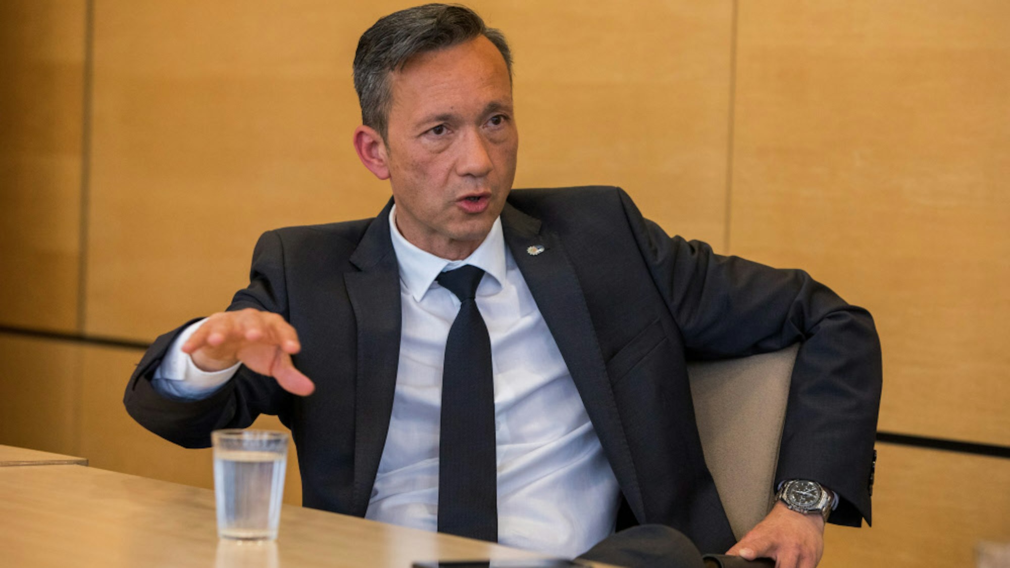 Kölns Polizeipräsident Falk Schnabel sitzt an einem Tisch und gestikuliert.