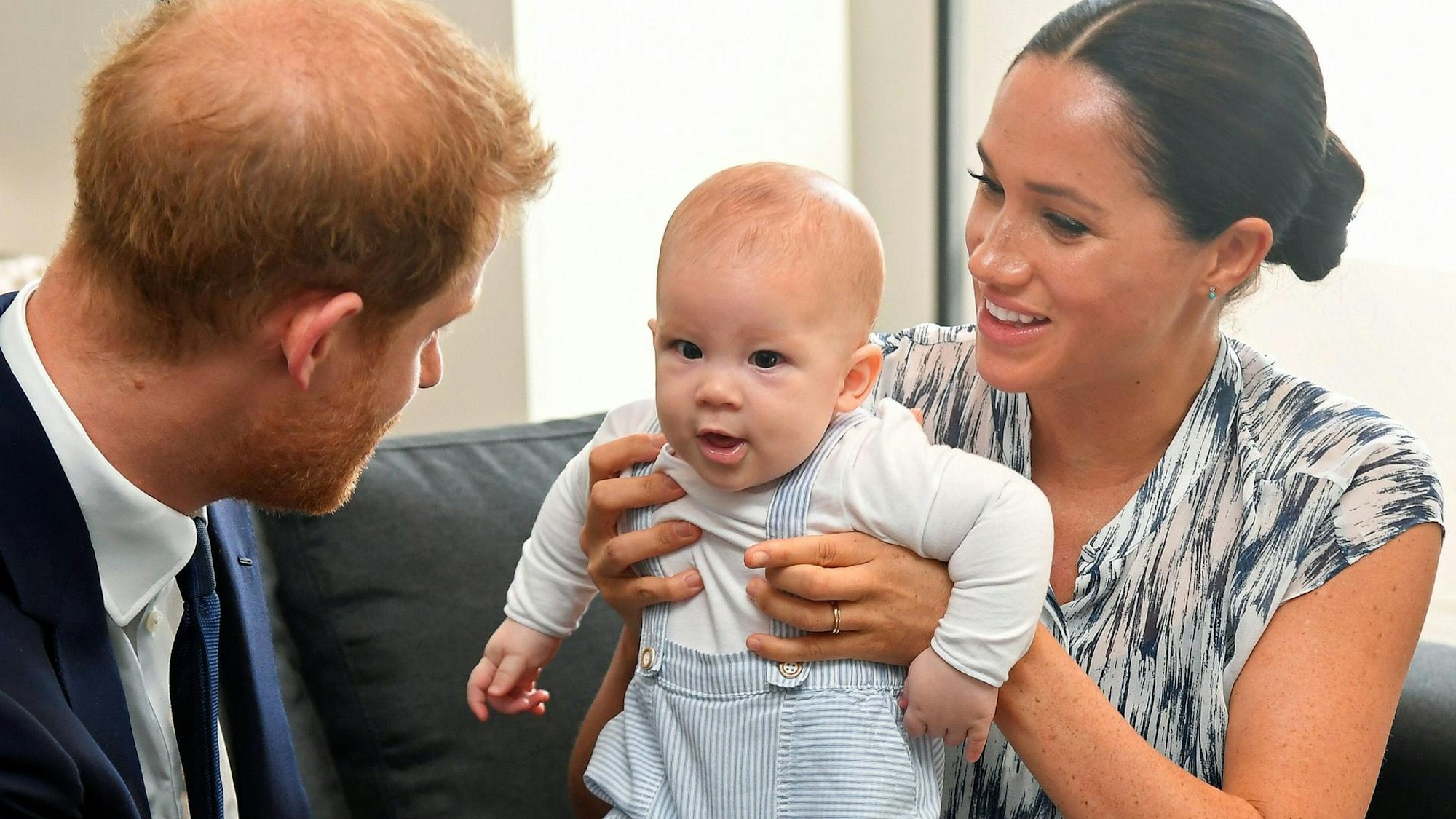 Prinz Harry und Meghan mit dem kleinen Prinz Archie auf einer Couch.