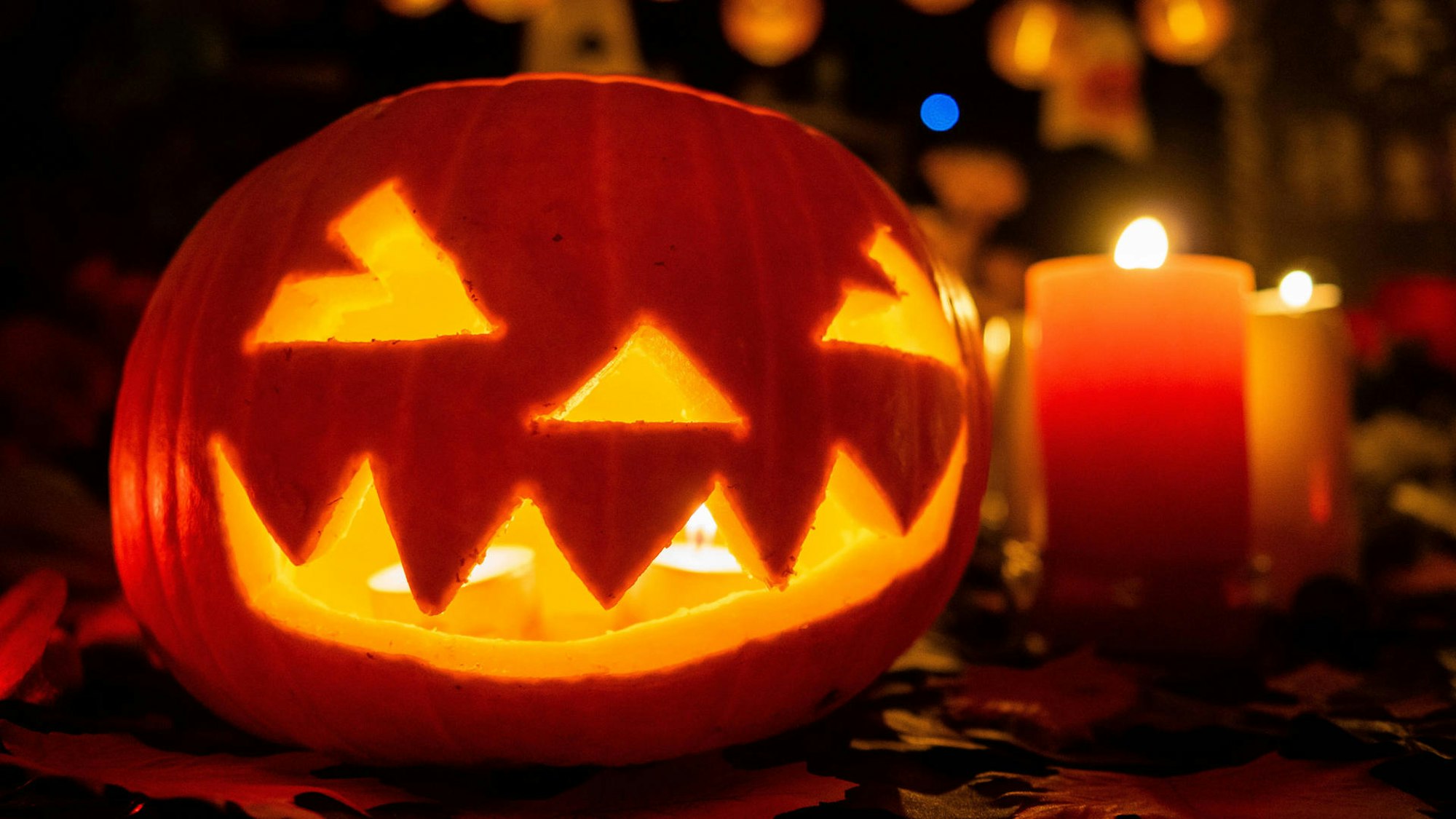 Leuchtender Kürbis und Kerzen.