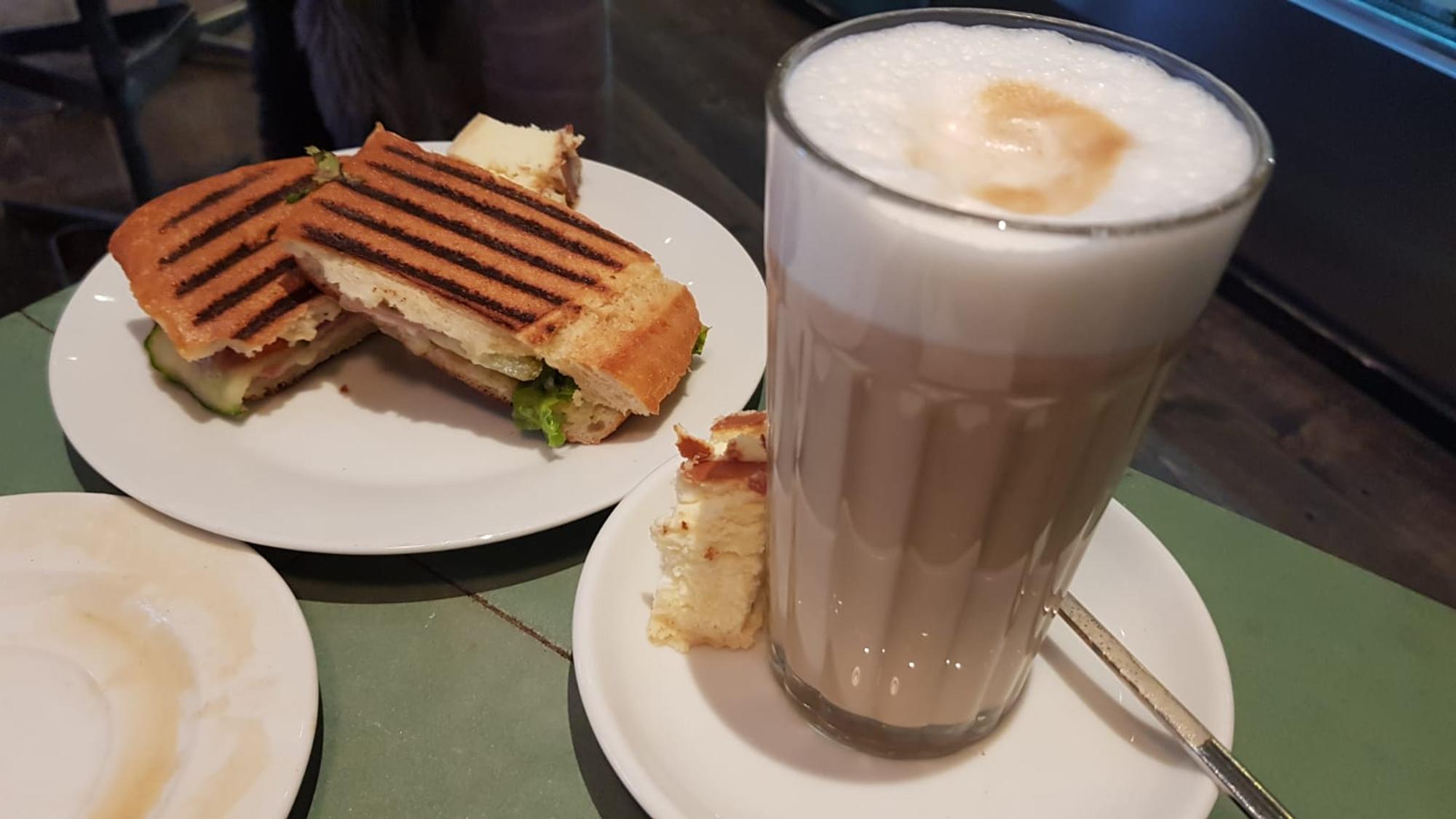 Kaffee und Ciabatta stehen beim Café Einspänner auf einem Tisch.