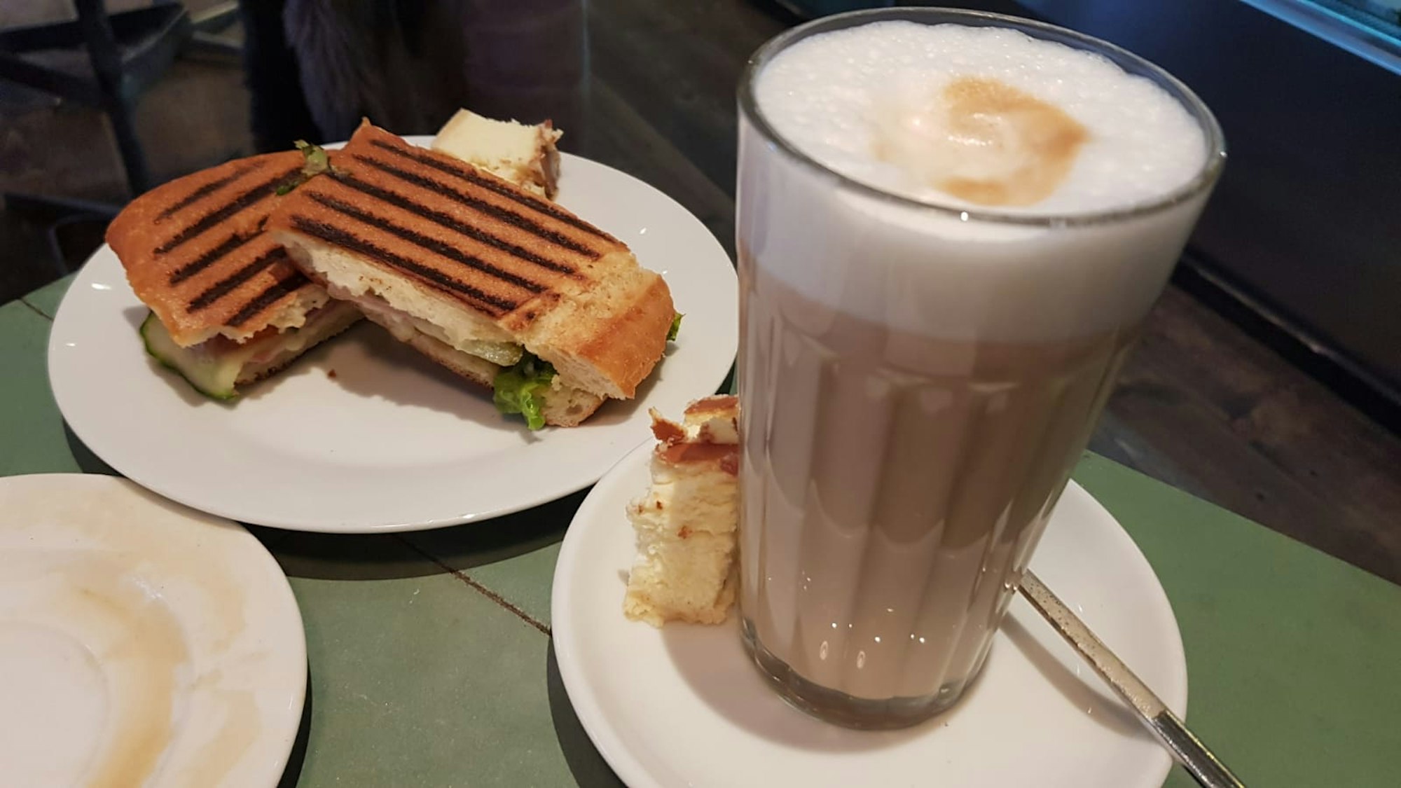 Kaffee und Chiabatte stehen beim Café Einspänner auf einem Tisch.
