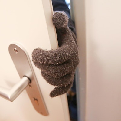 Dieb Einbrecher an Tür nur Handschuh zu sehen