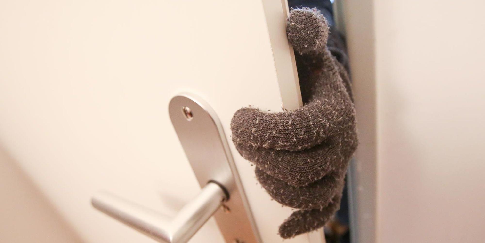 Dieb Einbrecher an Tür nur Handschuh zu sehen