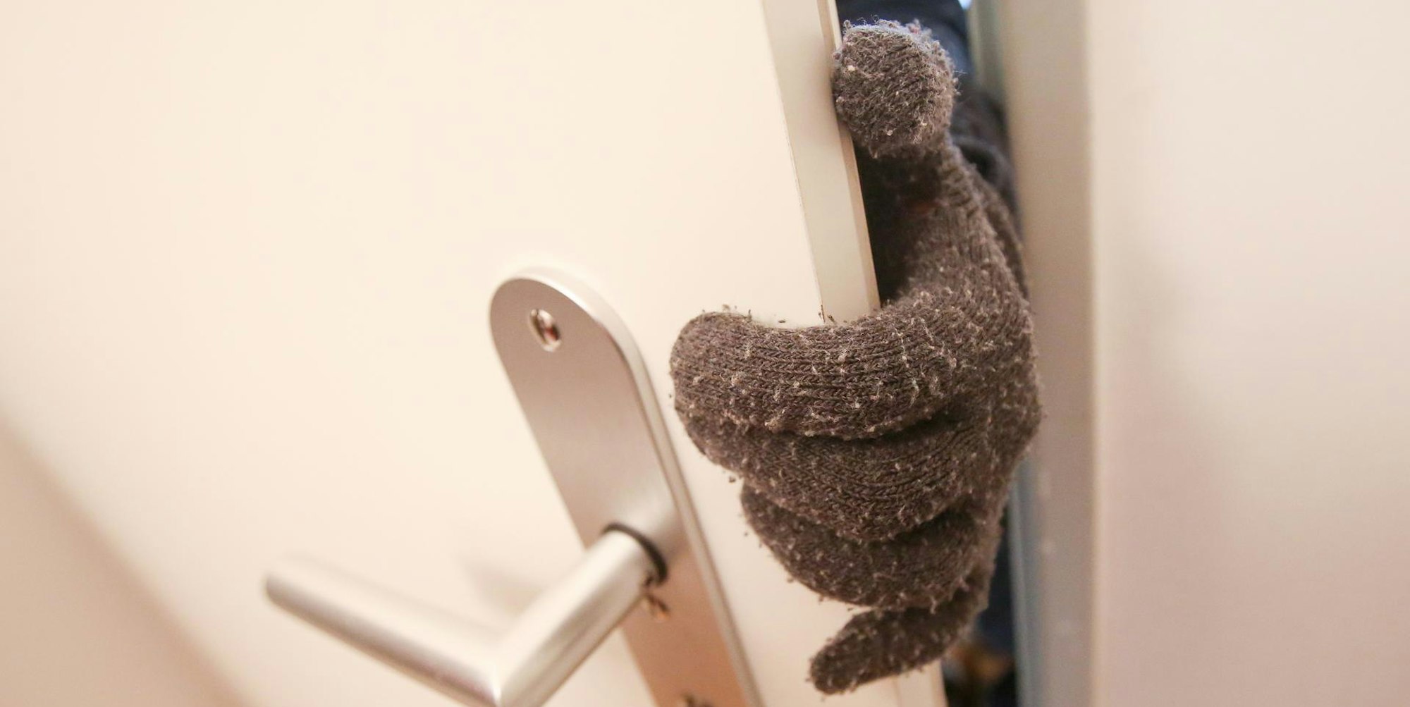 Dieb Einbrecher an Tür nur Handschuh zu sehen